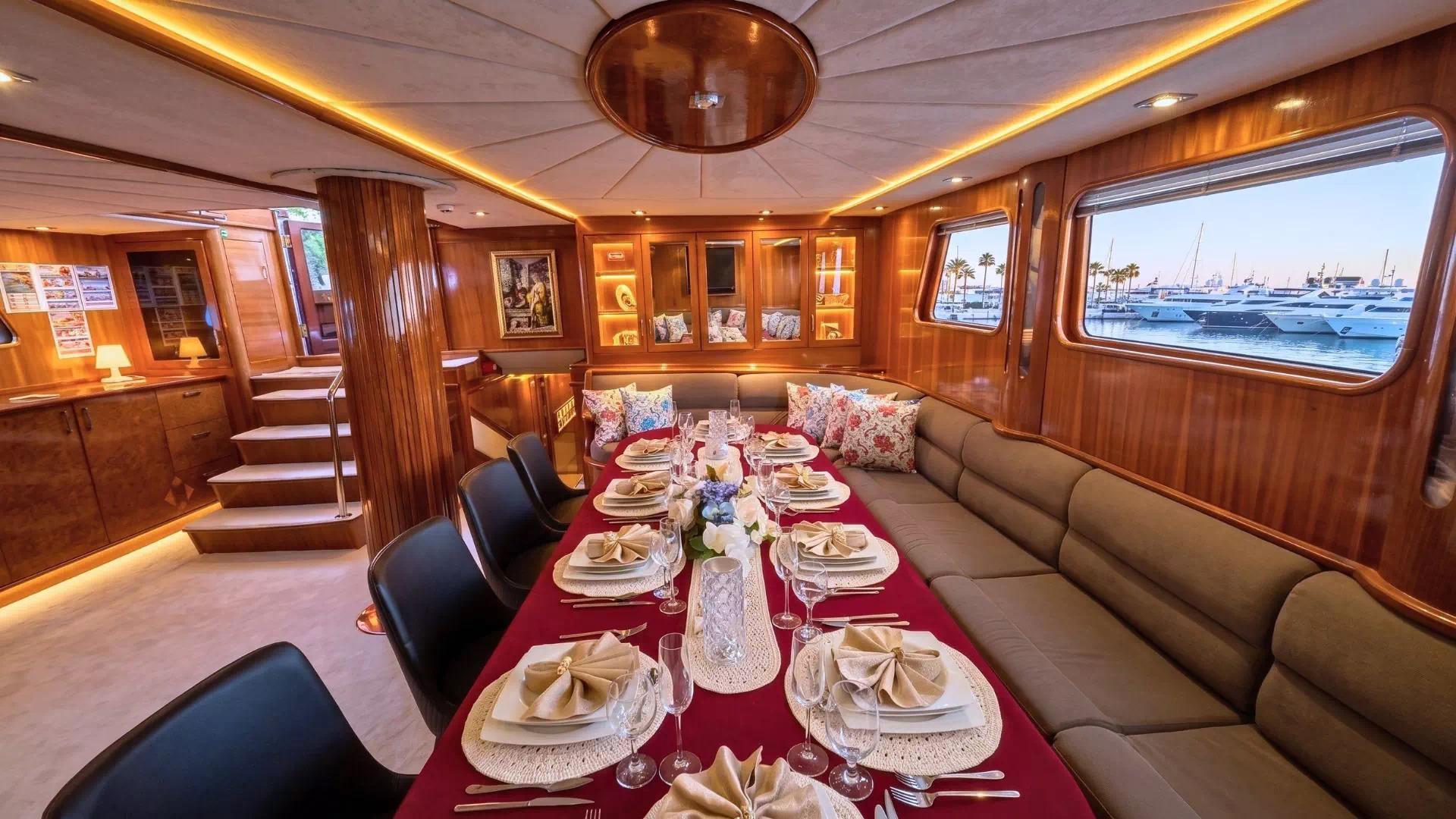 yacht dining salon with formal table setting, red tablecloth, wine glasses and place settings