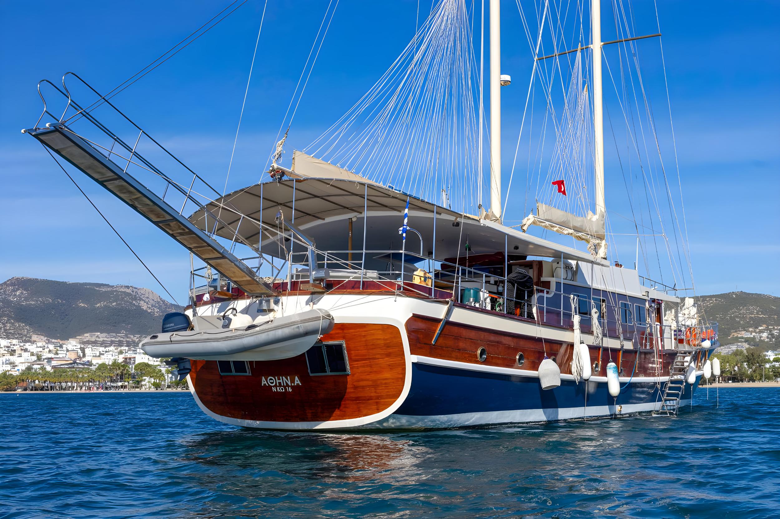 traditional wooden gulet with inflatable tender boat secured on stern transom