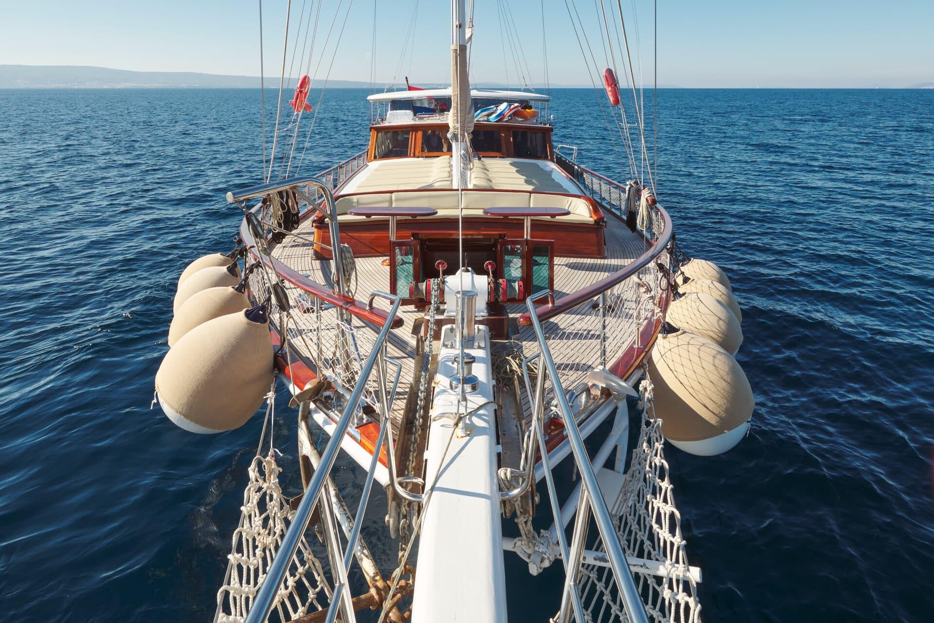 gulet bow perspective showing mast rigging and aft sun deck with loungers