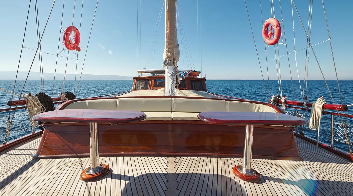 gulet foredeck seating area with curved upholstered bench around wooden table
