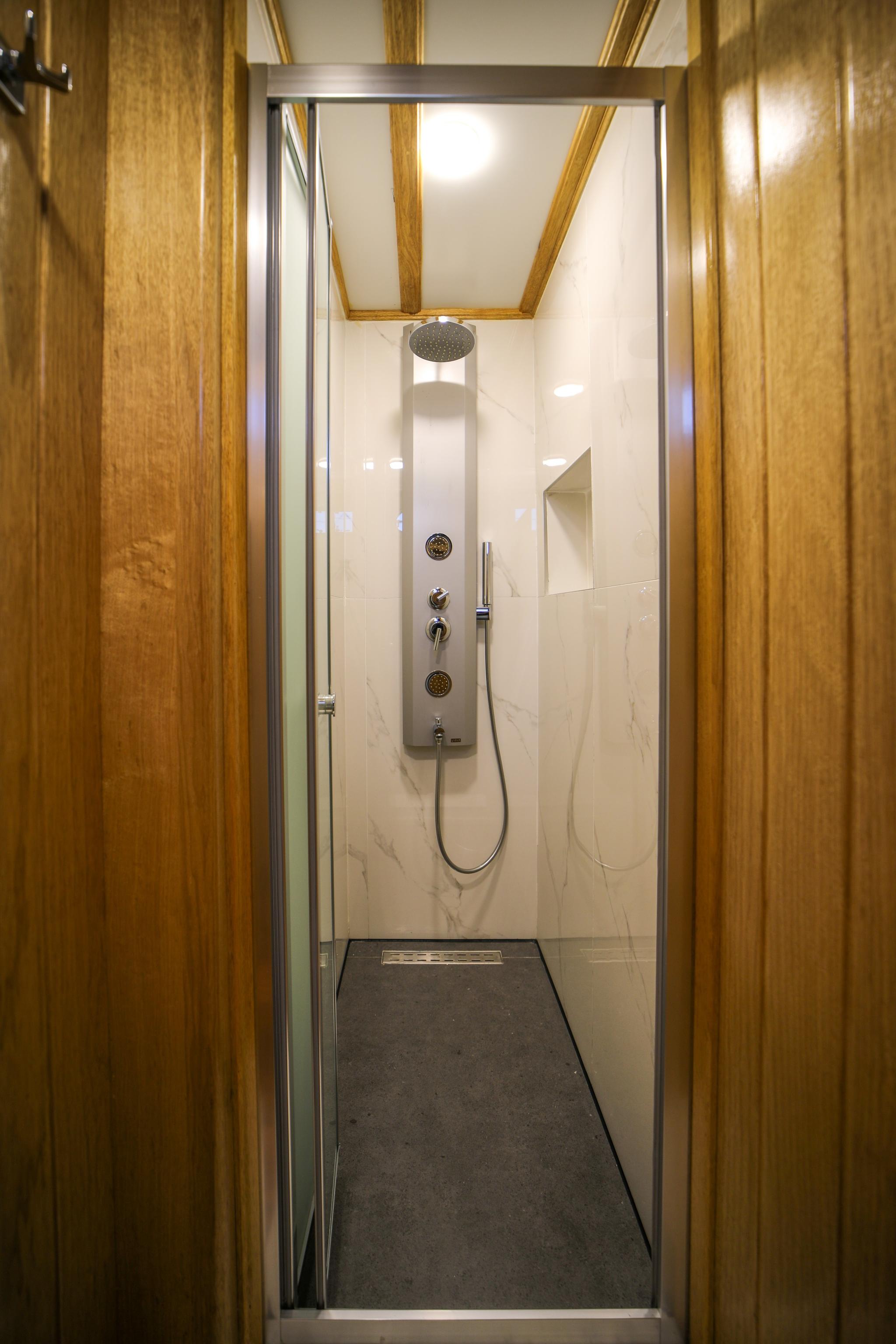 luxury yacht shower enclosure with marble walls and rainfall shower head