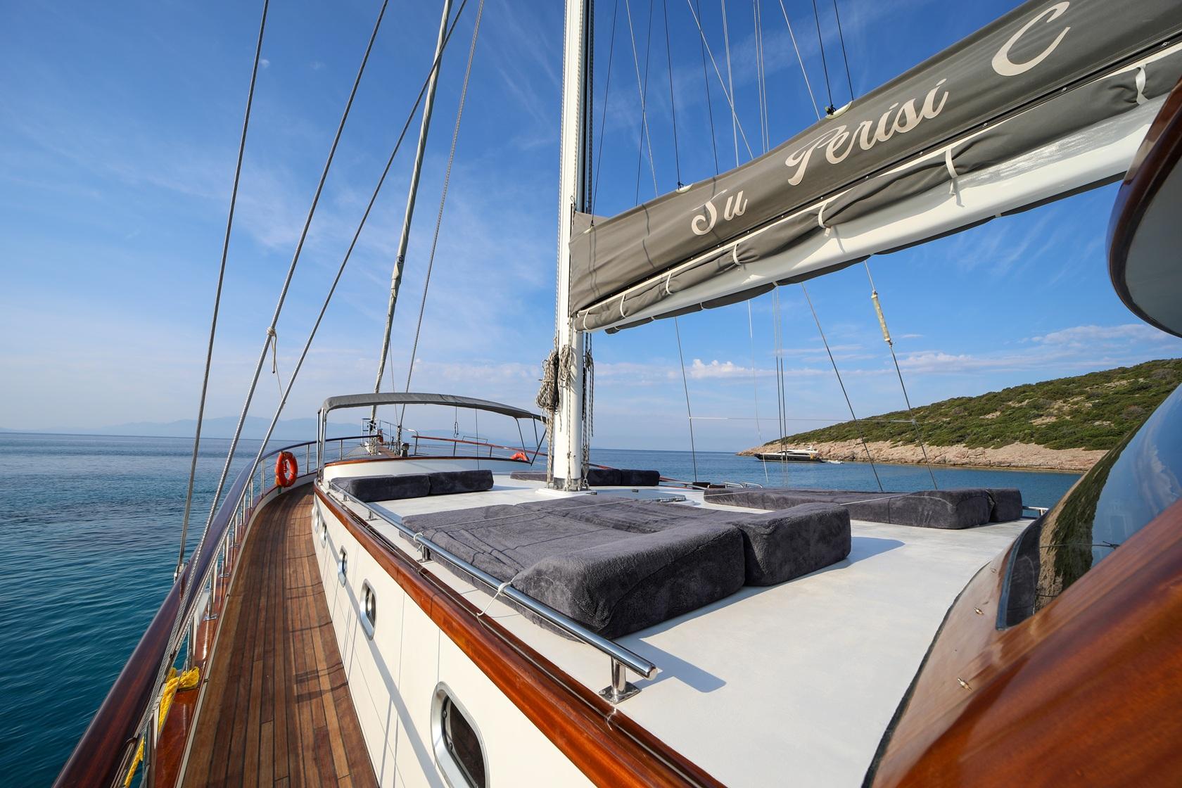 gulet forward deck with large cushioned sun loungers and sailing rigging