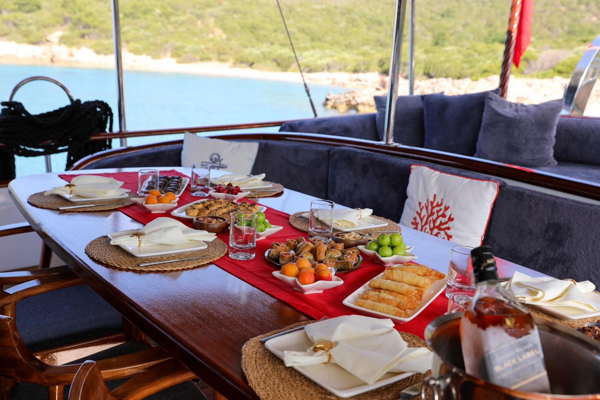 yacht dining table set with Mediterranean breakfast featuring fresh fruits, pastries, and traditional Turkish delicacies