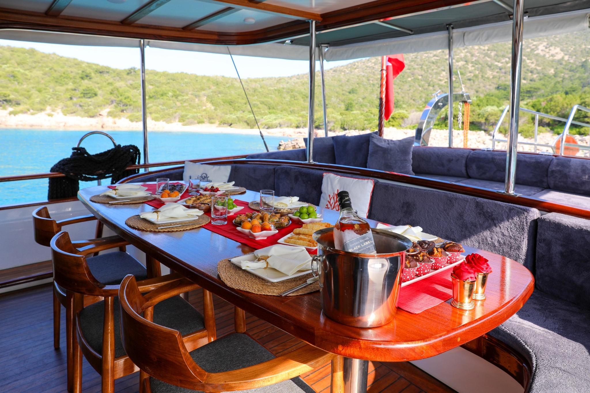 yacht aft deck dining table with Mediterranean lunch spread and wine service