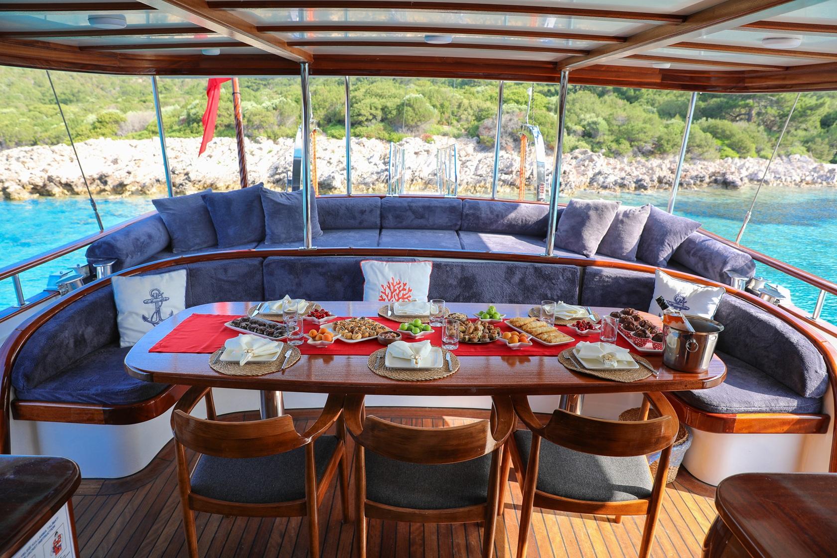 gulet dining table with full meal spread including multiple dishes and place settings