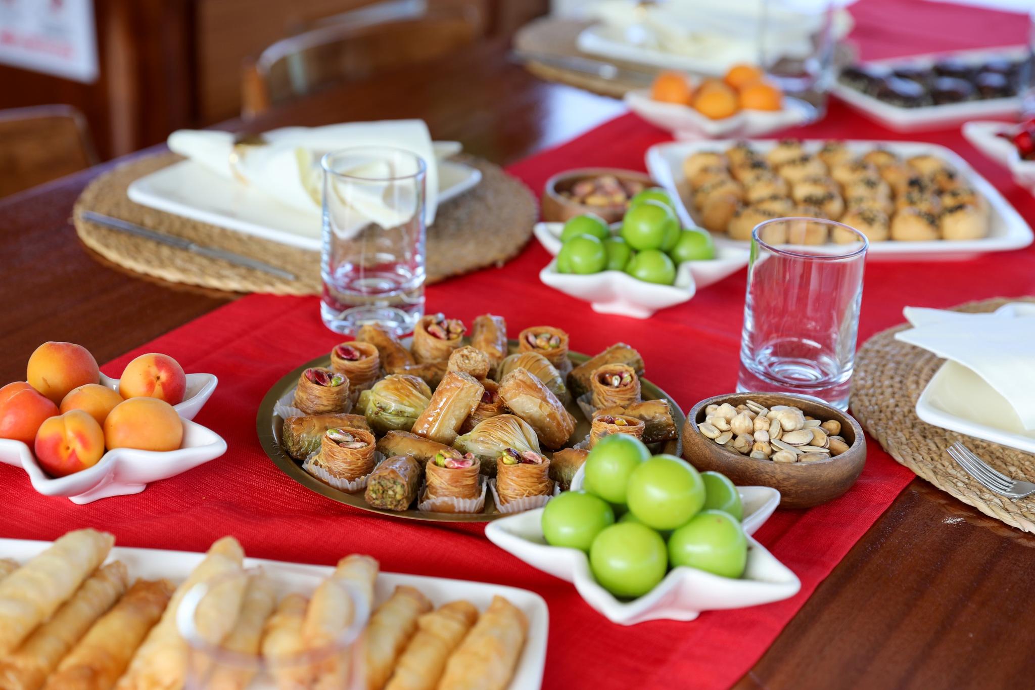 yacht dining table with baklava, Turkish sweets, fresh apples, grapes and nuts served