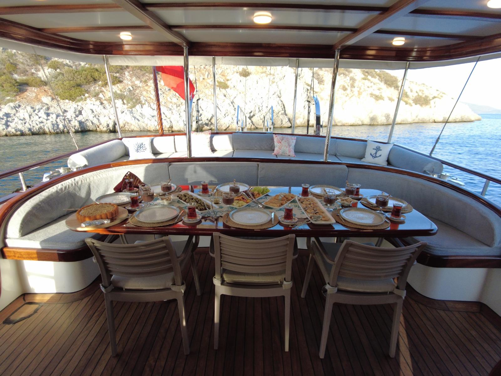 Covered outdoor dining area with set table featuring Turkish breakfast plates and tea glasses