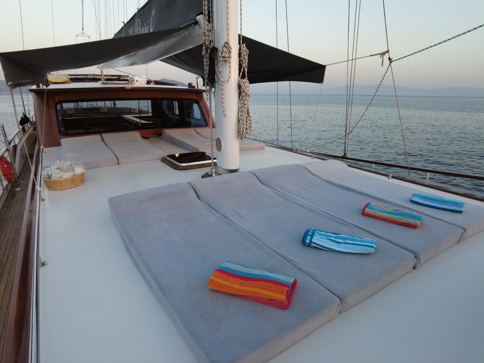 bow deck with gray sun loungers and colorful towels aboard sailing yacht