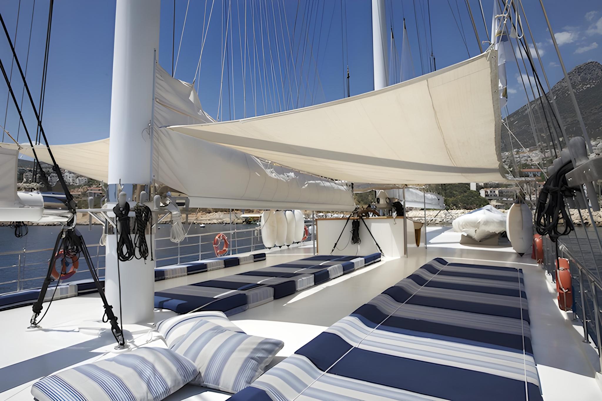 gulet bow deck with blue and white striped cushions under cream shade sail