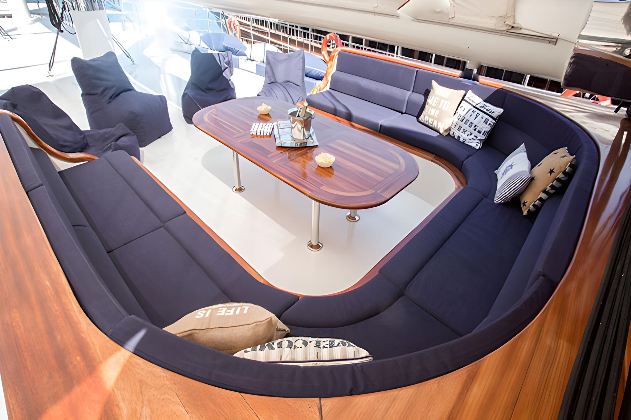 yacht salon interior with navy blue U-shaped sofa seating around oval coffee table