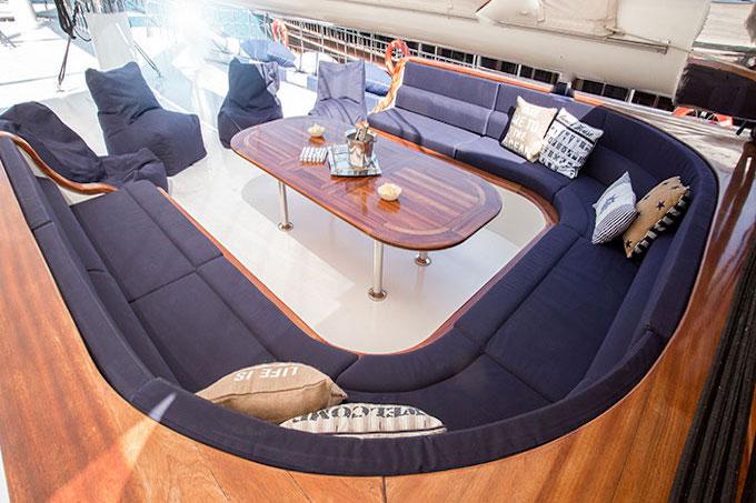 yacht salon interior with navy blue U-shaped sofa seating around oval coffee table