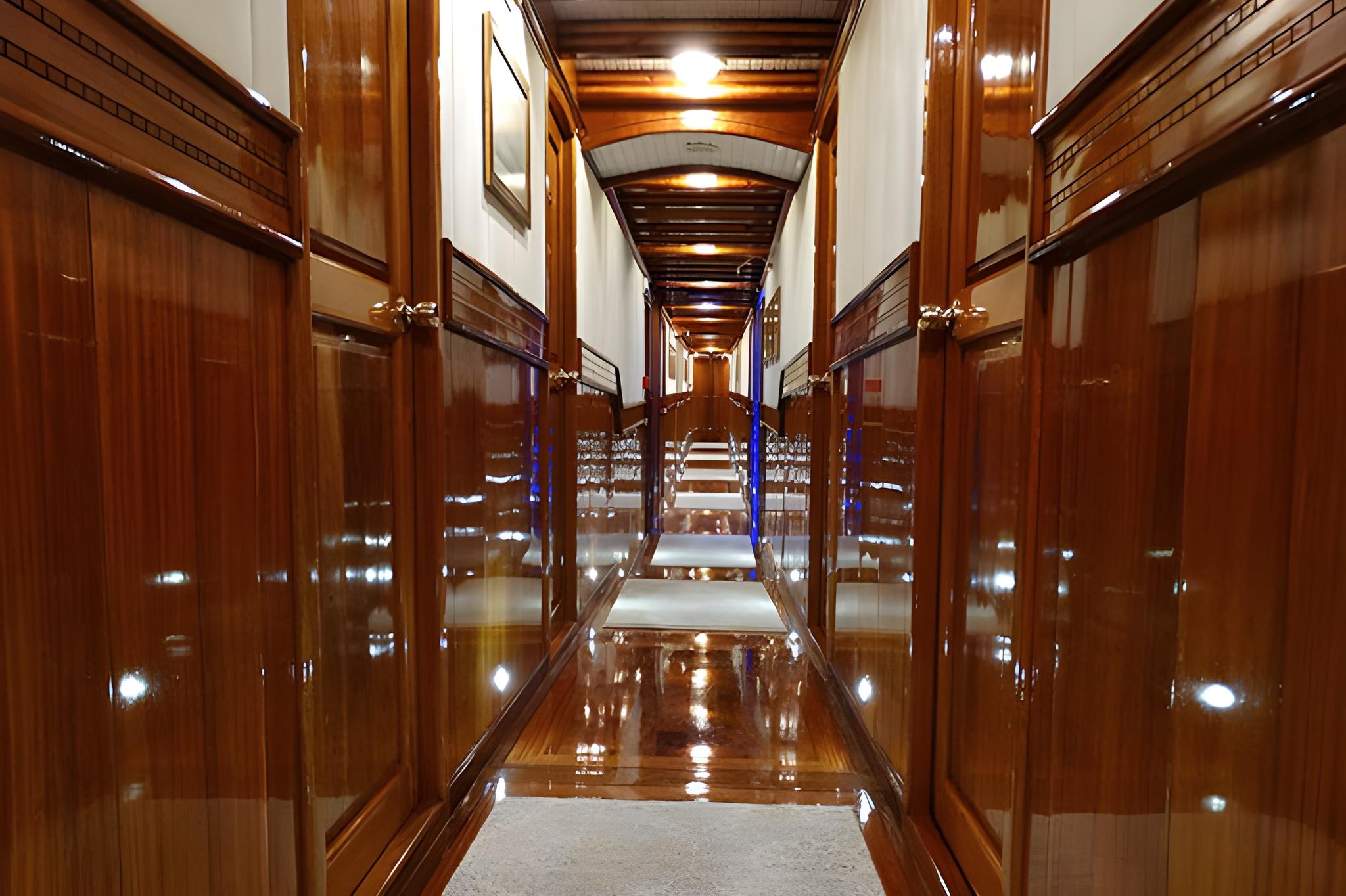 luxurious yacht corridor with glossy mahogany wood paneling and marble flooring leading to staircase