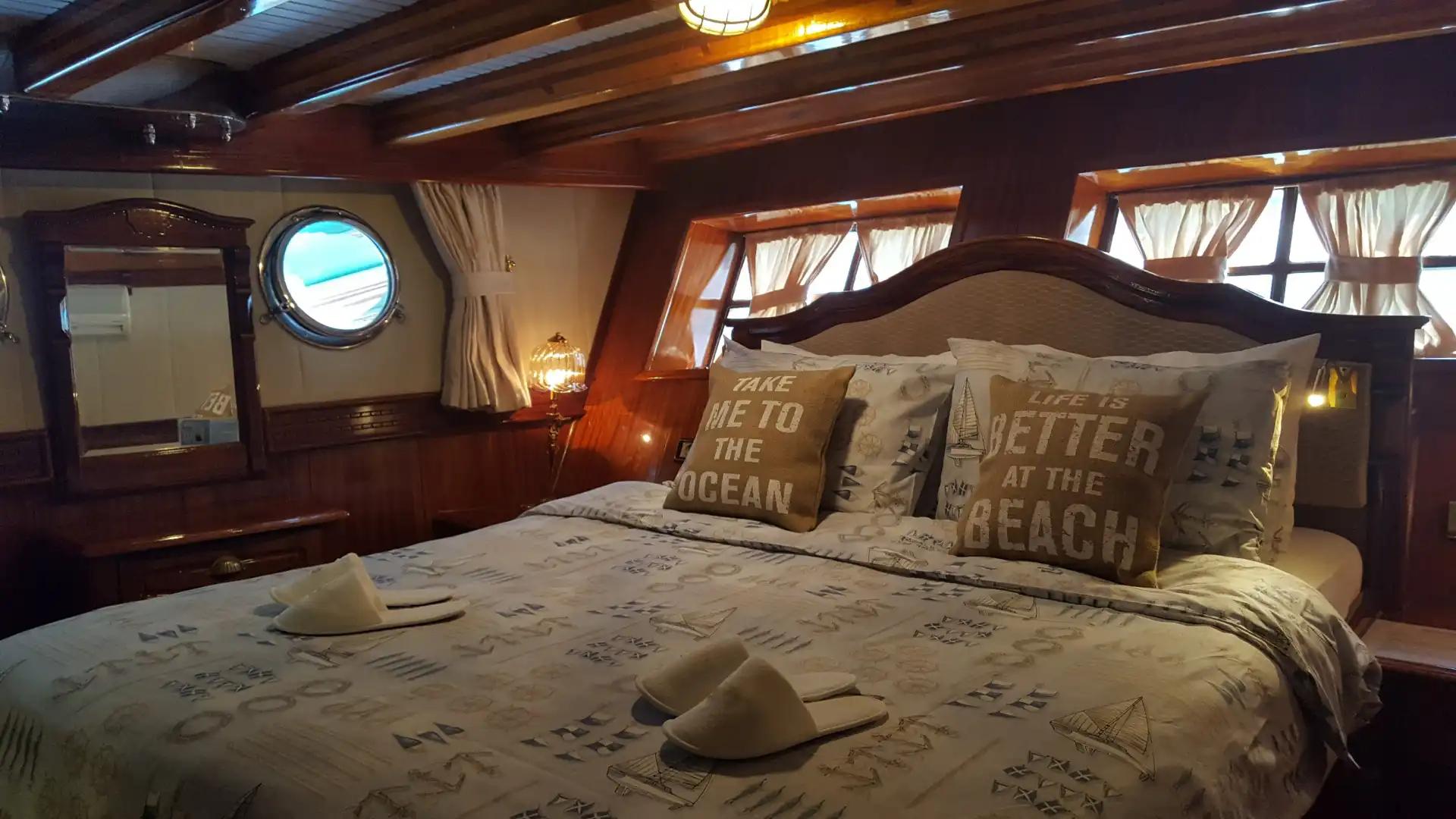 yacht guest cabin featuring double bed with nautical print bedding and decorative pillows