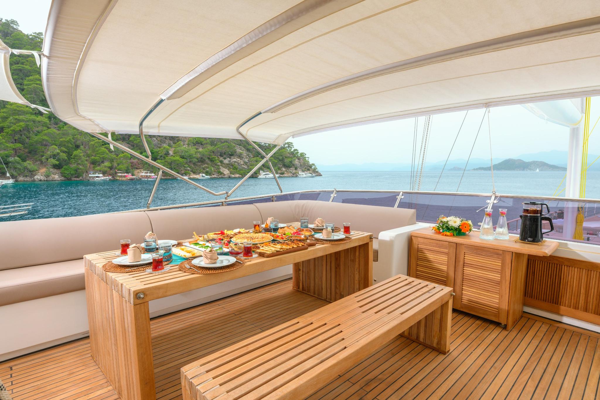 outdoor dining area with traditional Turkish breakfast spread on teak table under bimini