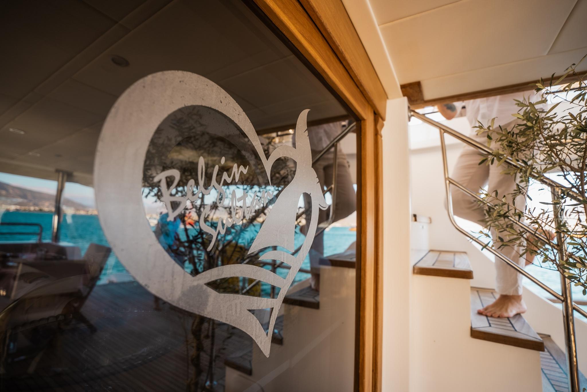 yacht interior staircase with etched logo on glass door and turquoise sea view
