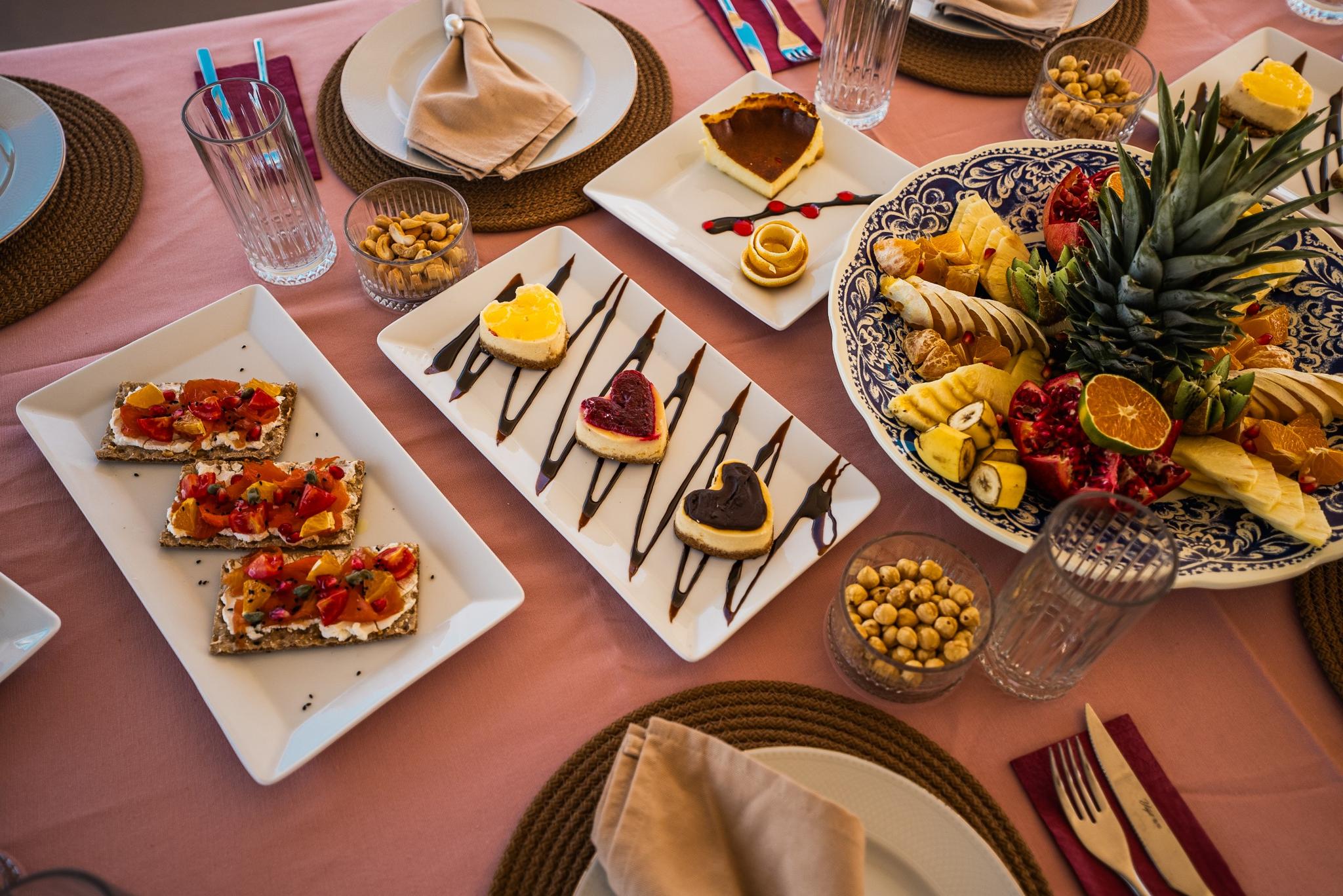 luxury yacht dining table with gourmet appetizers, desserts, fruit platter and formal place settings