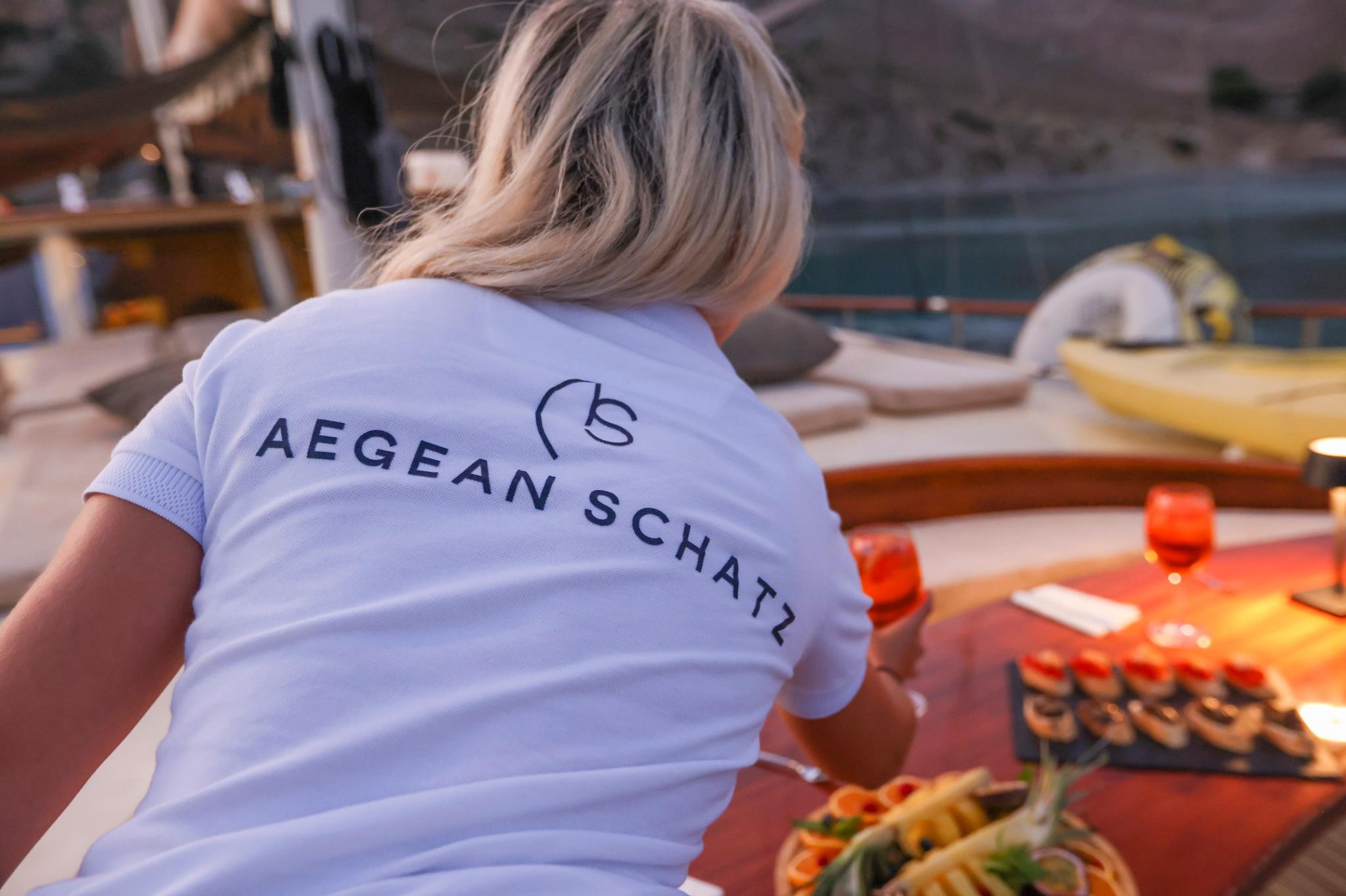 Yacht crew member in Aegean Schatz uniform cooking food on deck grill