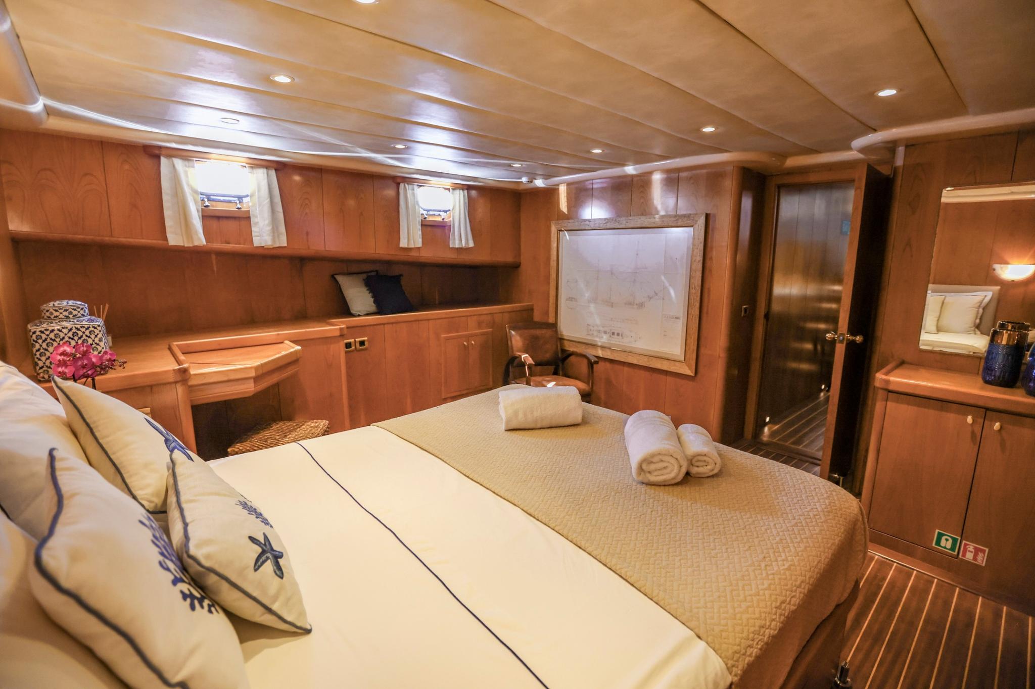 yacht master cabin featuring double bed with nautical bedding and wall-mounted television