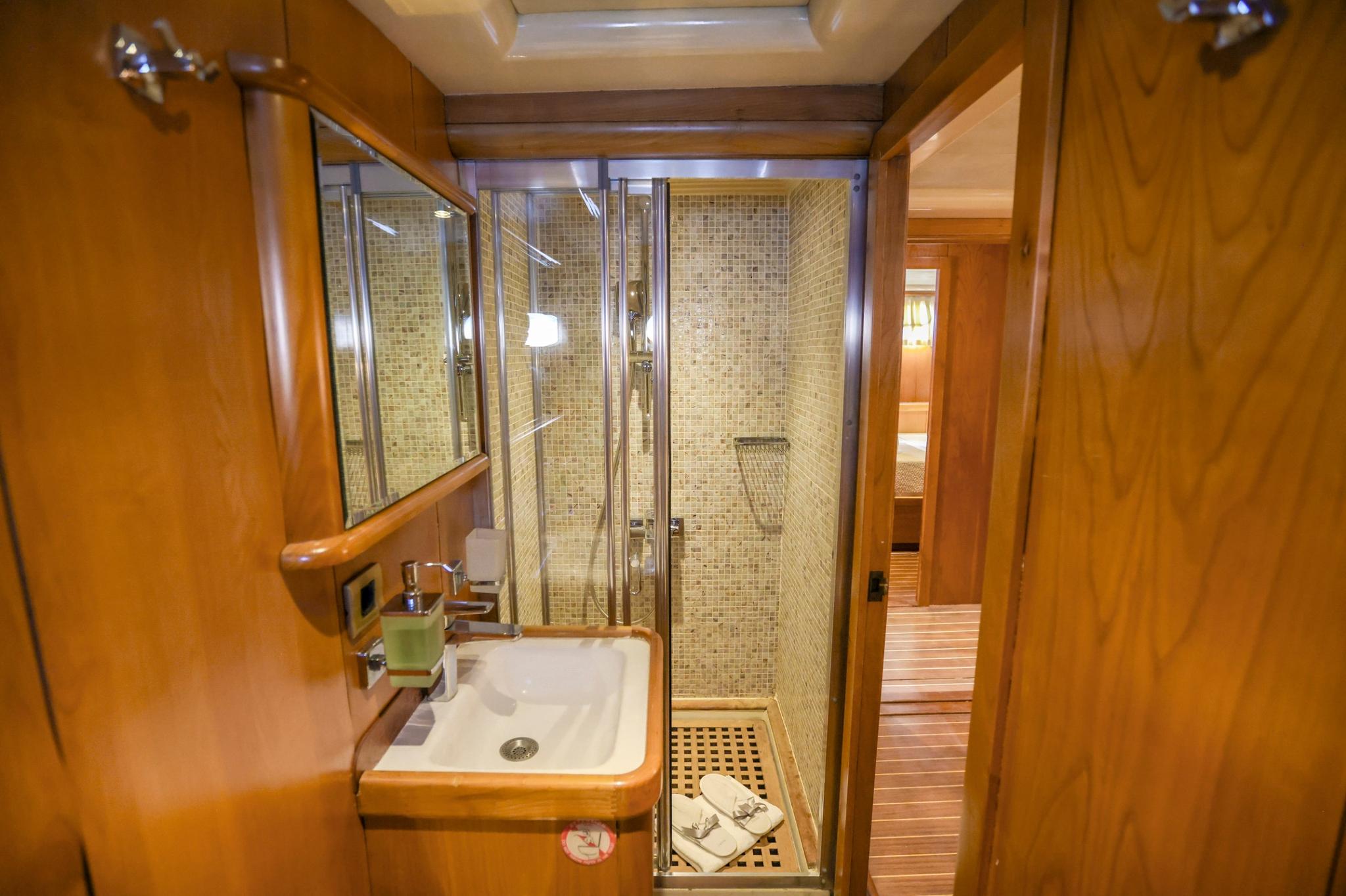 yacht bathroom featuring glass enclosed shower with mosaic tiles and white sink