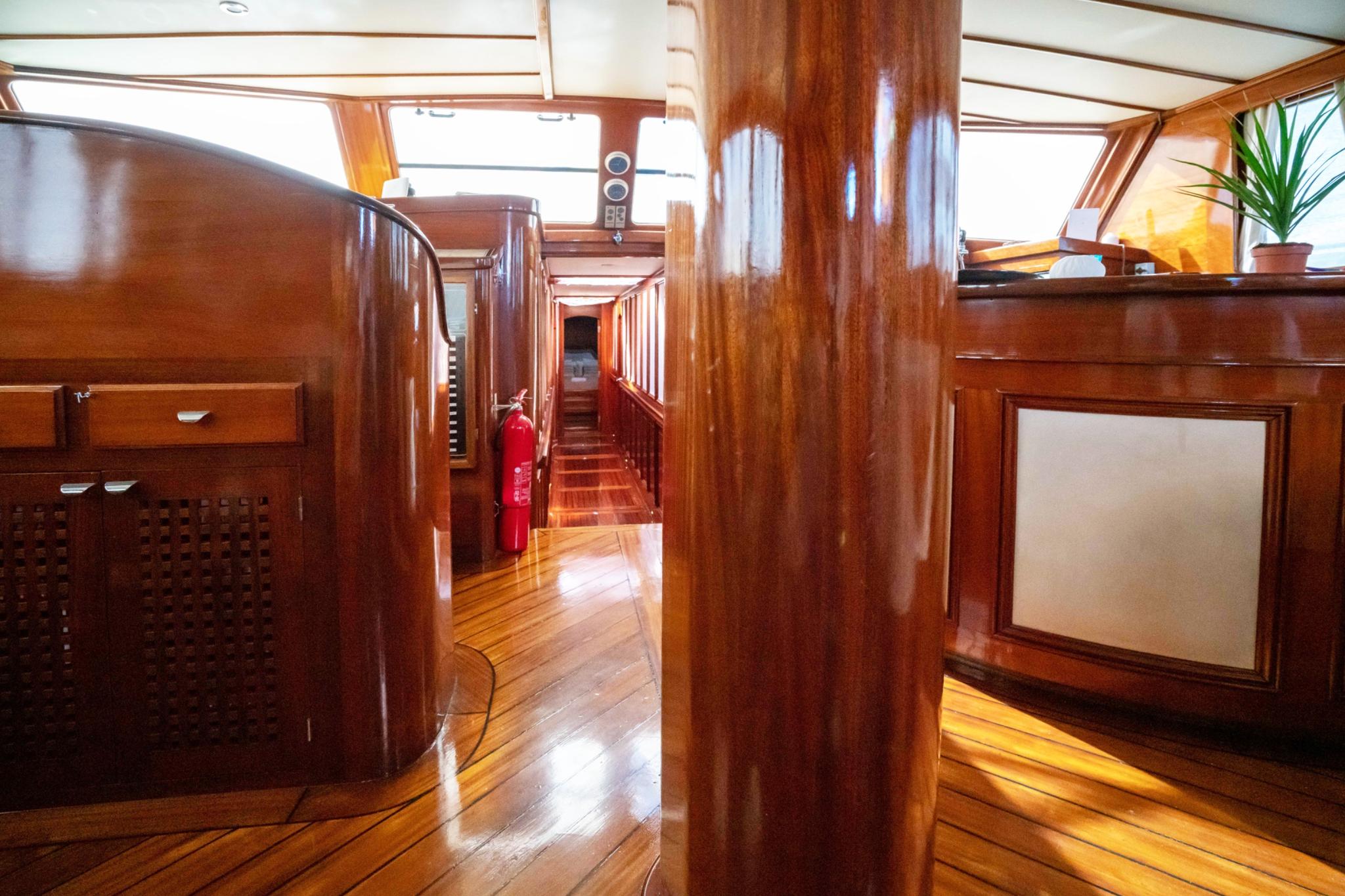 yacht interior corridor with rich mahogany woodwork and teak flooring