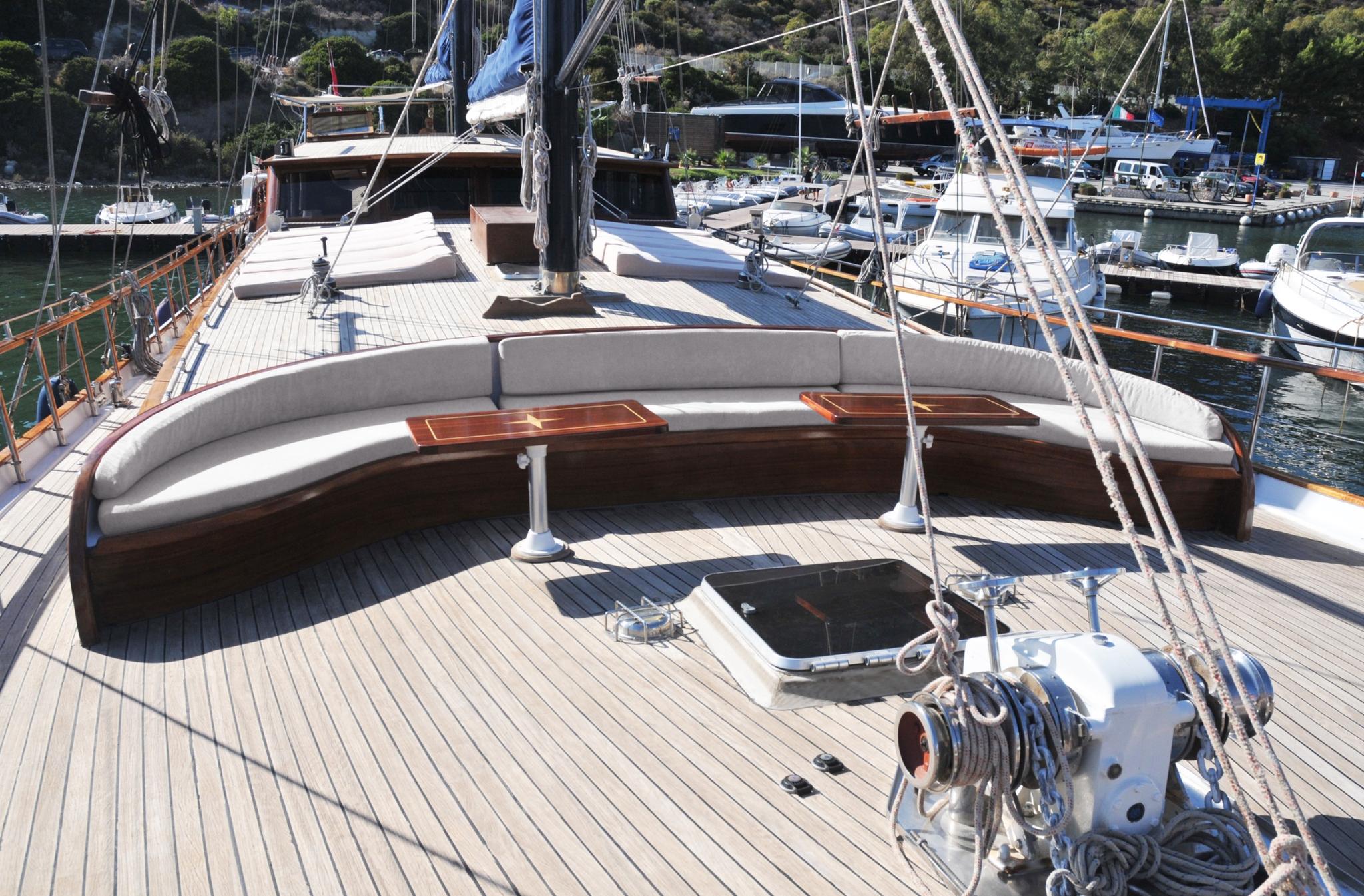curved banquette seating with cream cushions on gulet foredeck with teak decking