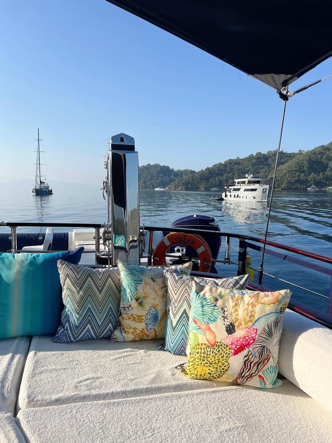yacht aft deck seating area with decorative cushions and pillows overlooking calm bay