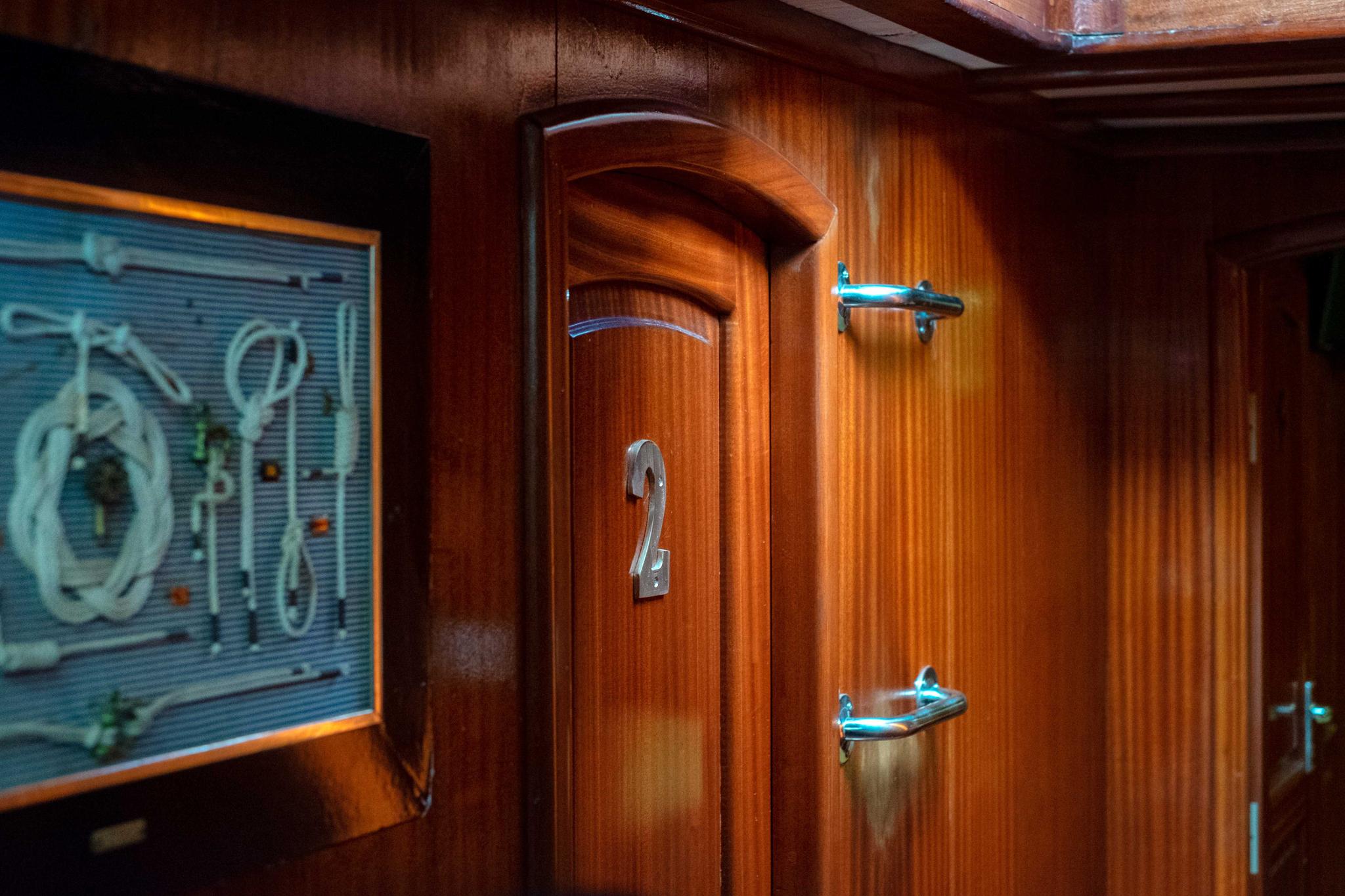 yacht interior corridor with rich wood paneling and cabin entrance doors