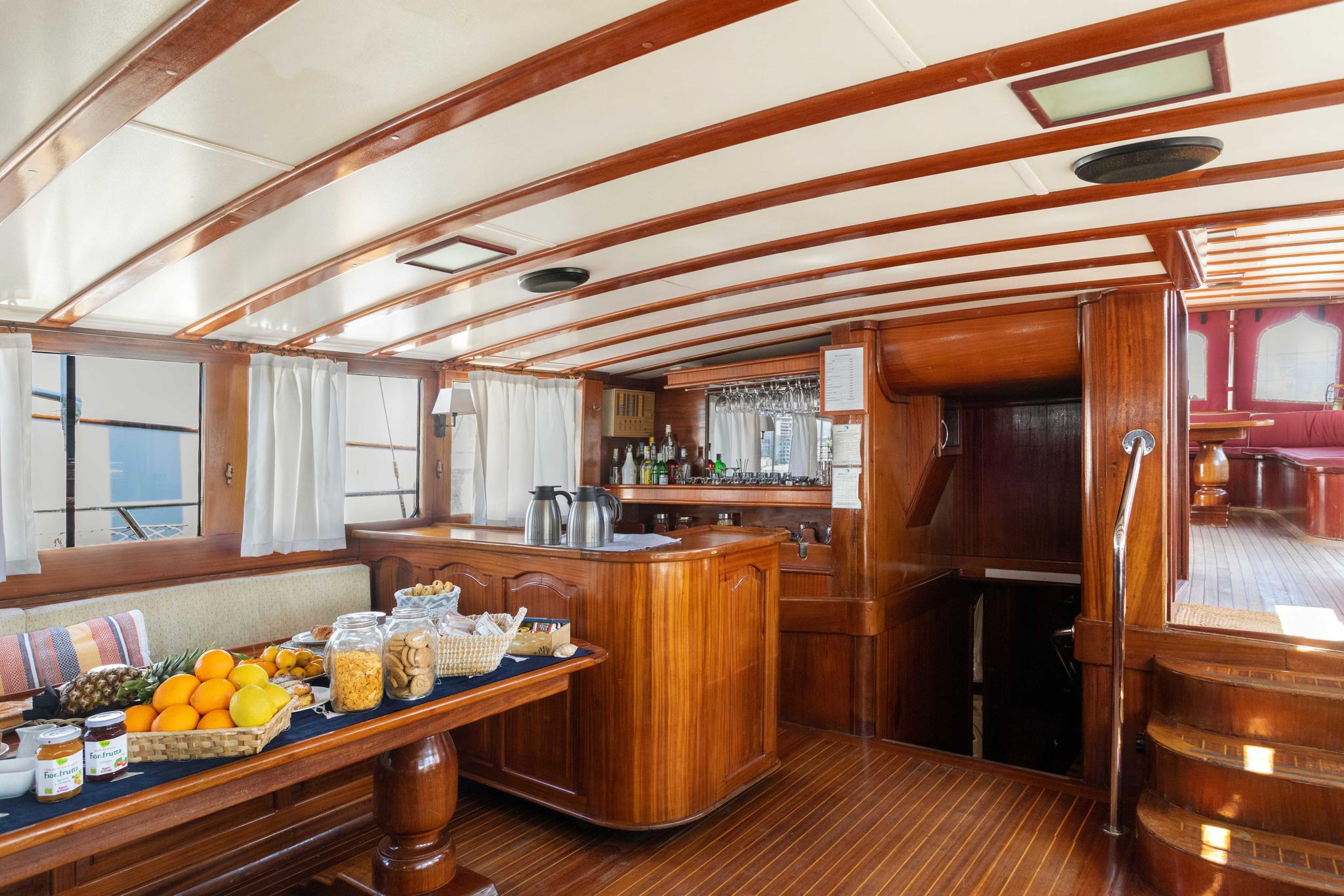yacht galley interior with breakfast buffet featuring fresh fruits and pastries