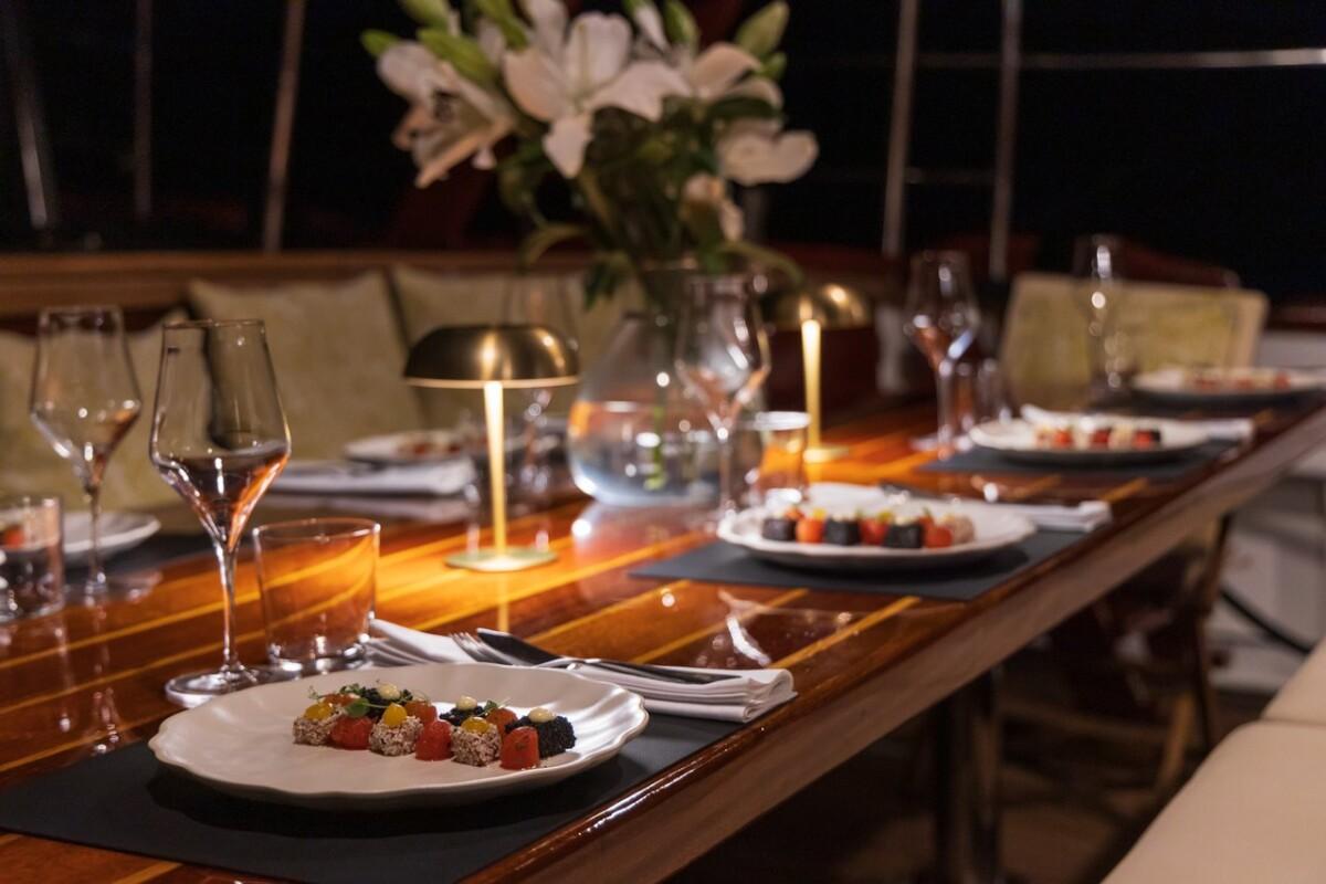 luxury yacht dining table set with sushi plates wine glasses candlelight