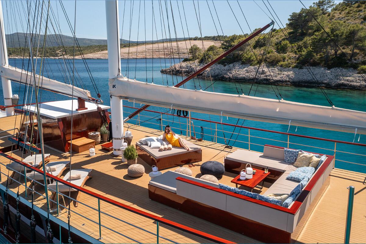 Luxury gulet main deck with outdoor lounge seating overlooking turquoise bay
