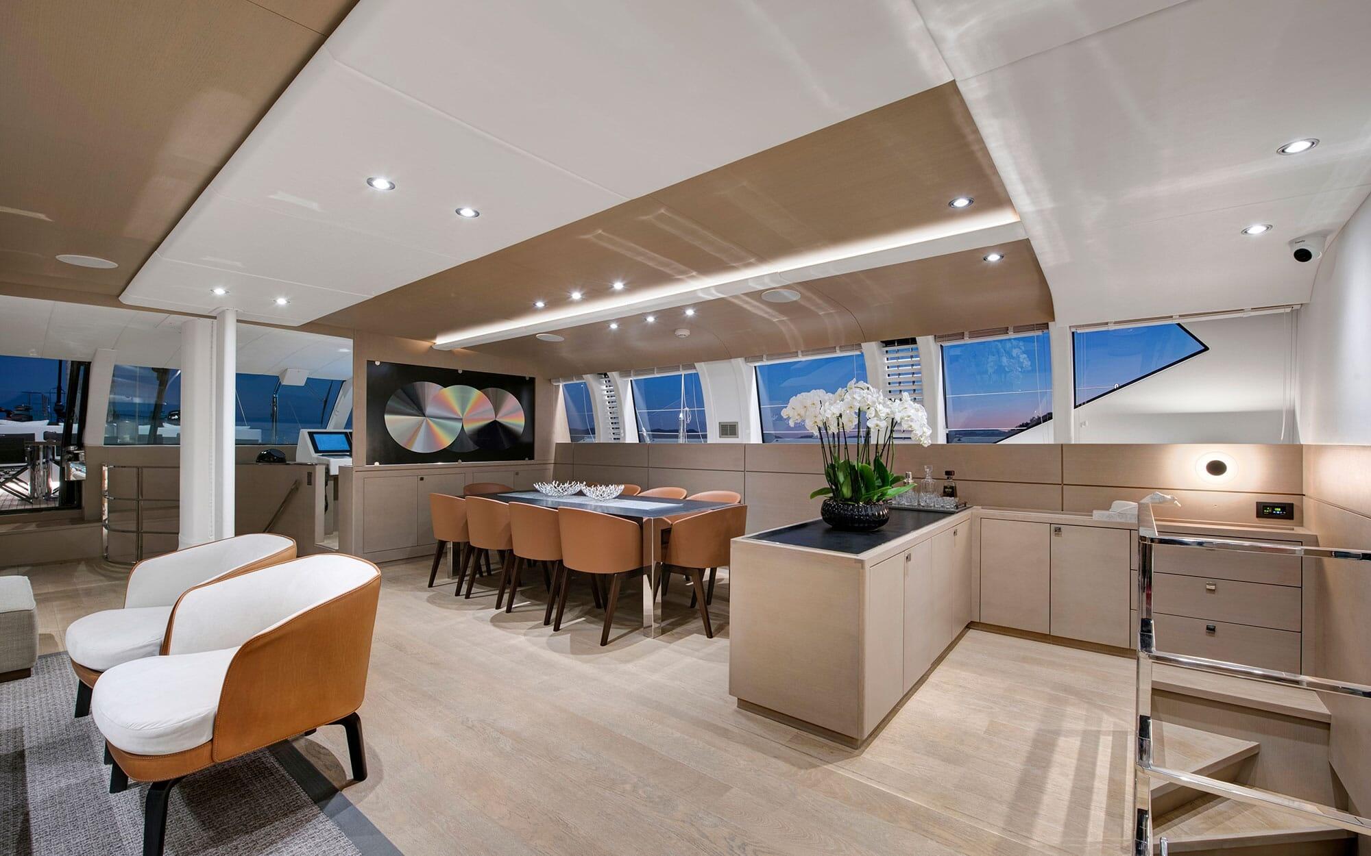 modern yacht salon interior with open galley kitchen dining table and lounge seating