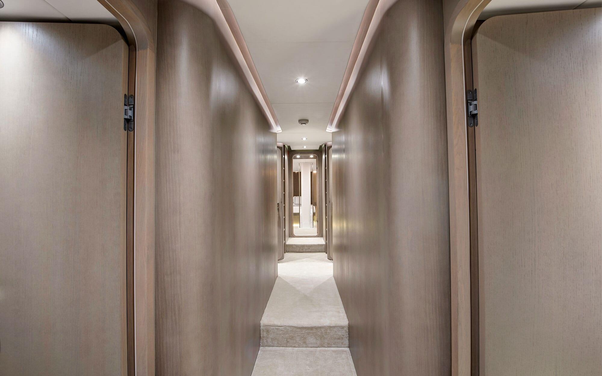 luxury yacht corridor with wooden cabin doors, LED ceiling lighting and marble floor
