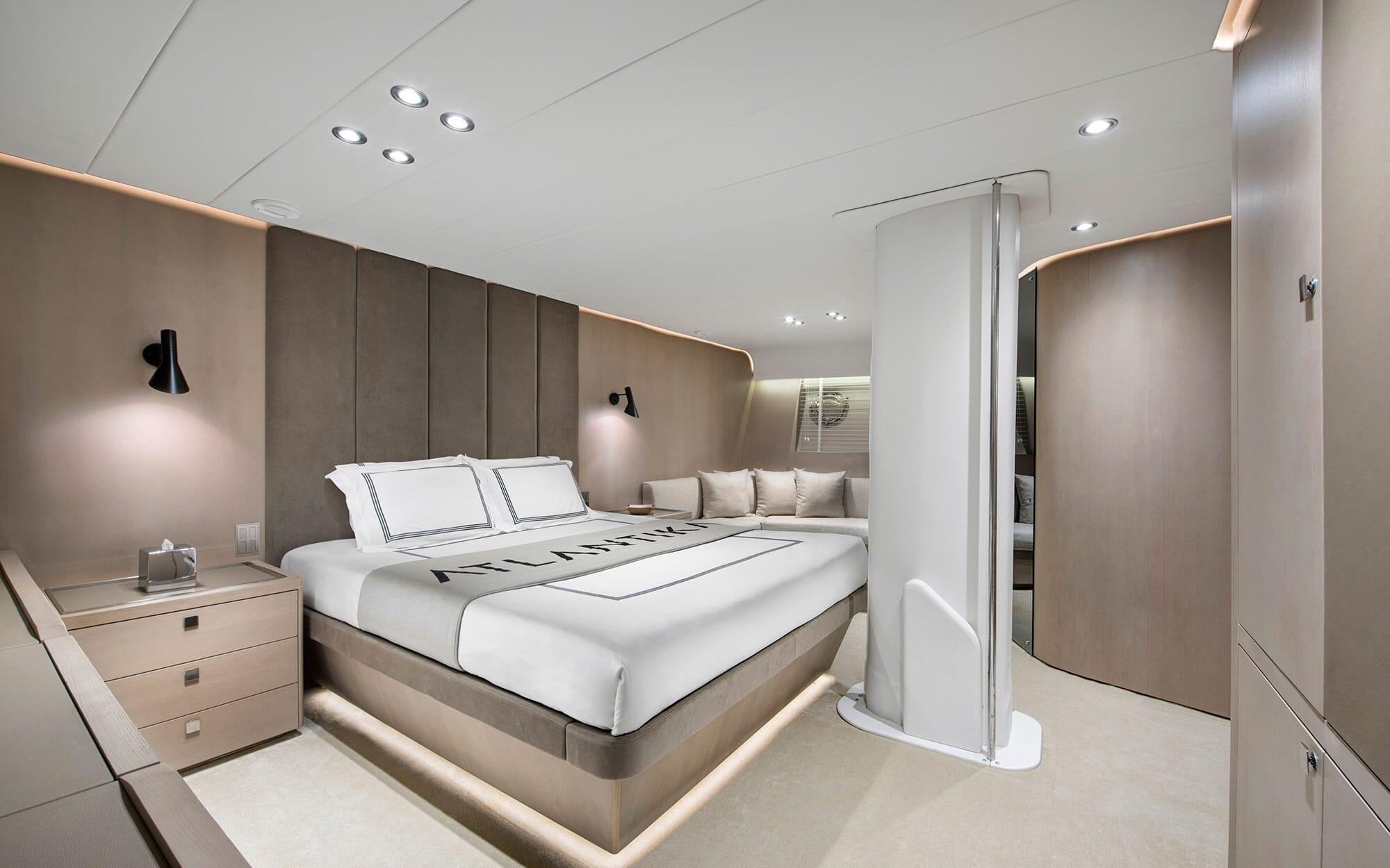 luxury yacht guest cabin featuring double bed with upholstered headboard and corner seating