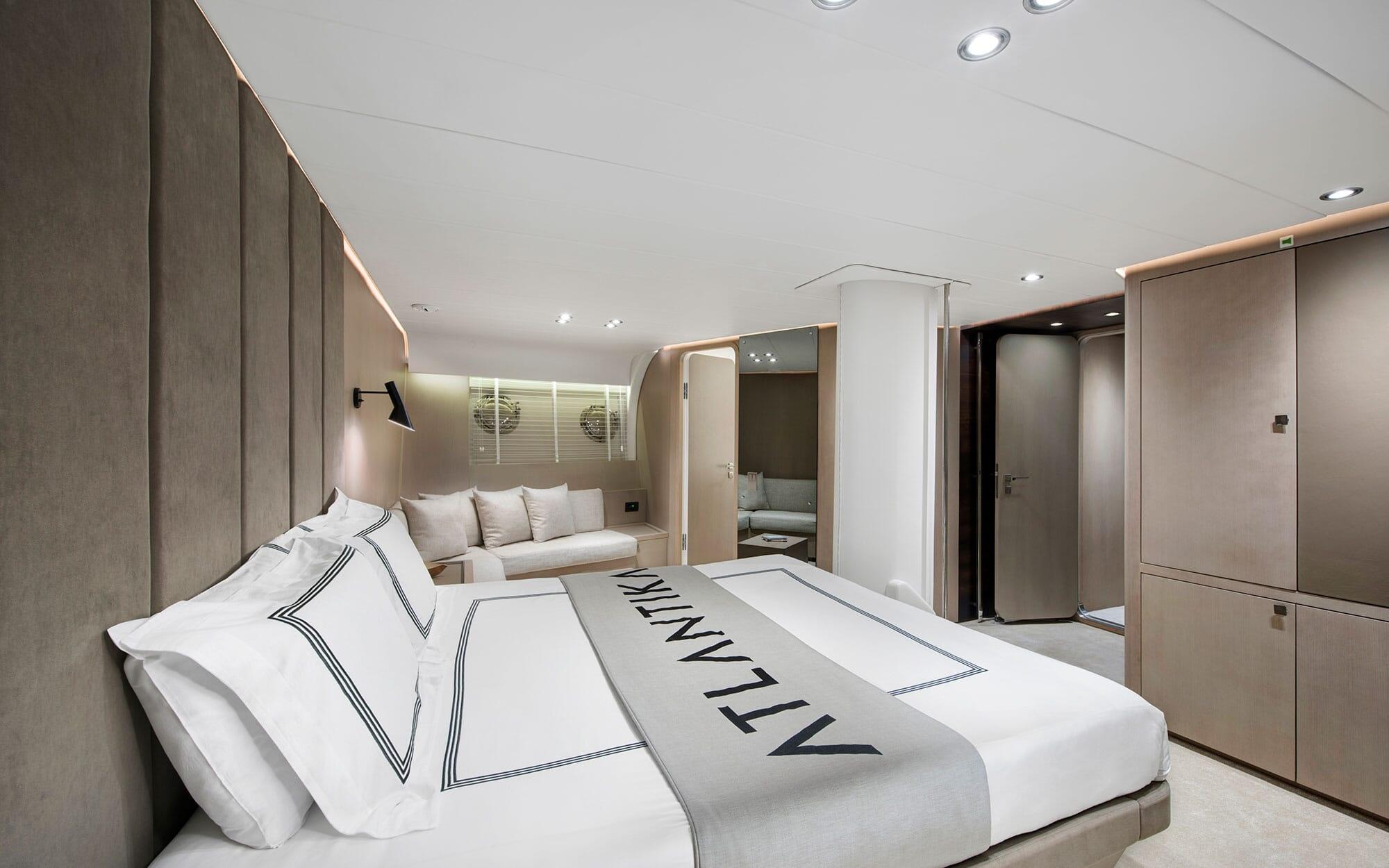 Spacious yacht master cabin featuring king bed with white linens, built-in seating area, and ensuite bathroom
