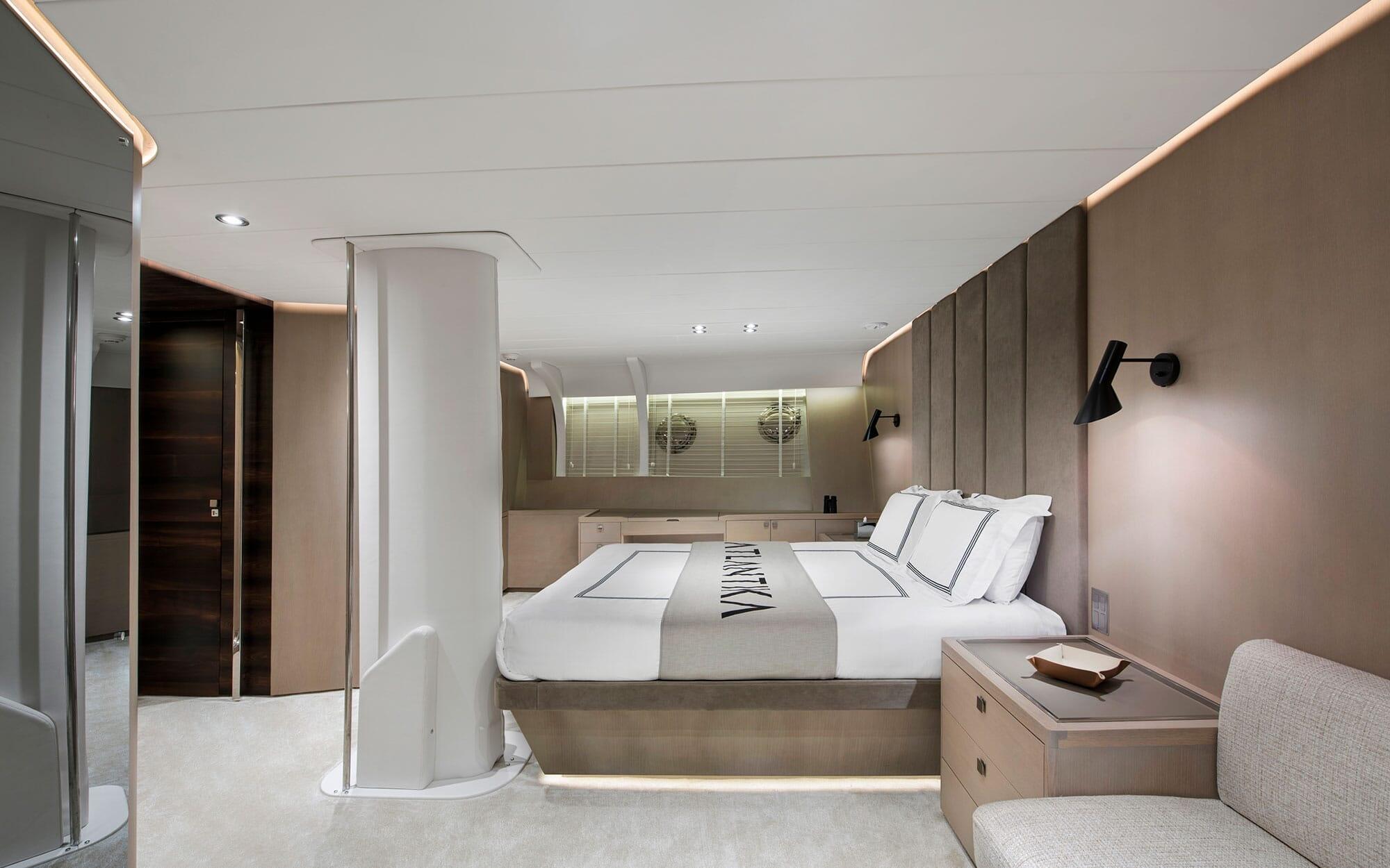 modern yacht cabin featuring double bed with white linens and glass-enclosed bathroom