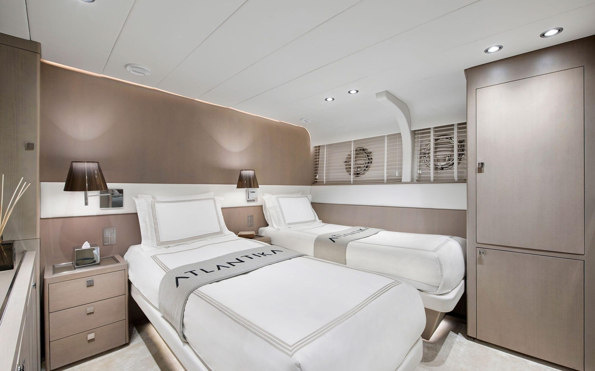 yacht twin cabin with two single beds, bedside tables and built-in wardrobe