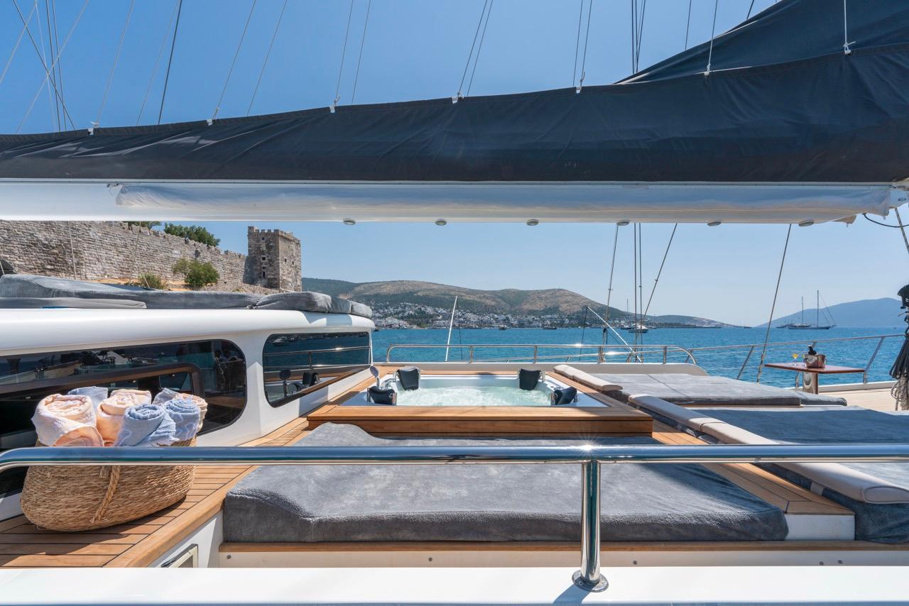yacht deck jacuzzi with teak wooden surround and grey cushioned seating area