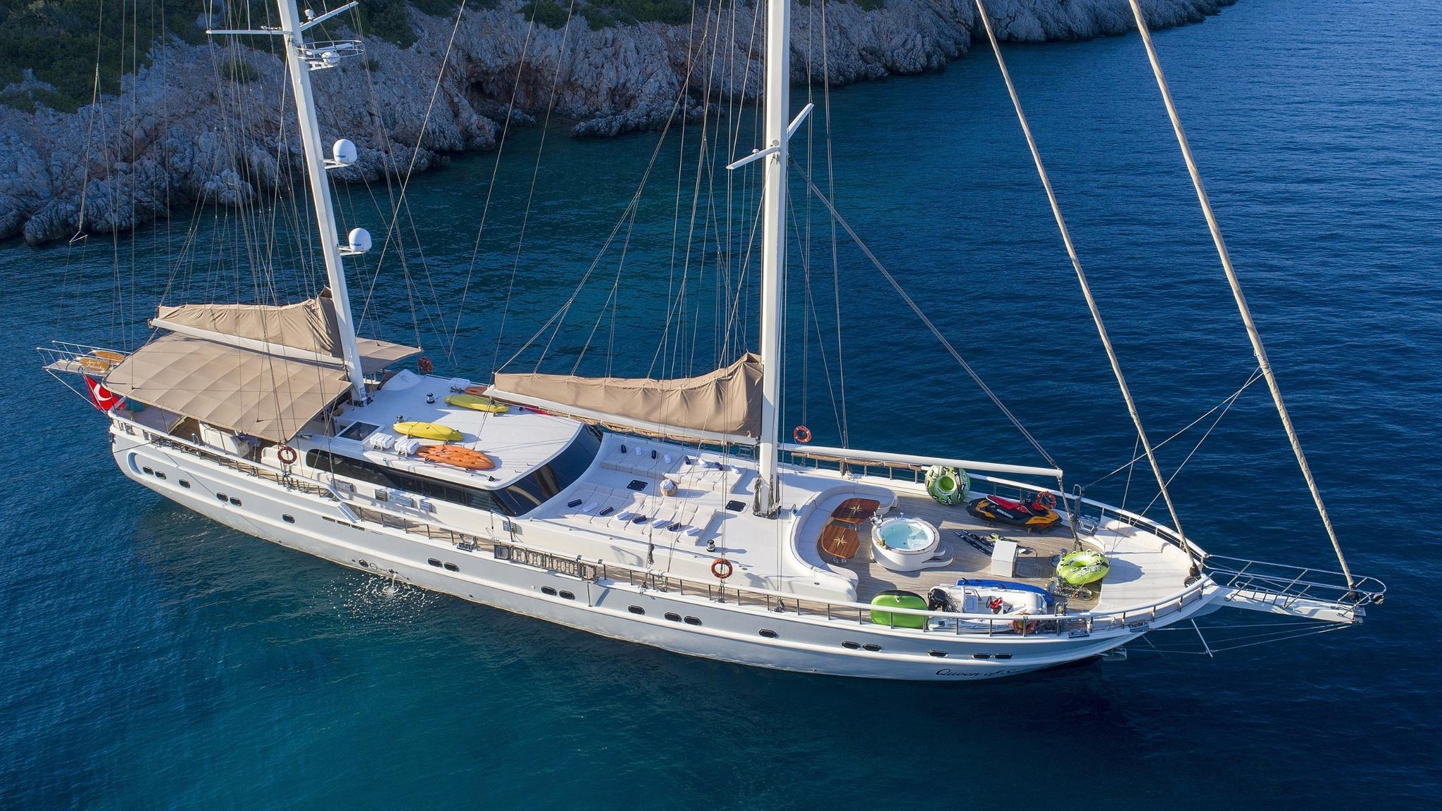 luxury sailing yacht with onboard jacuzzi and colorful water toys anchored in turquoise bay