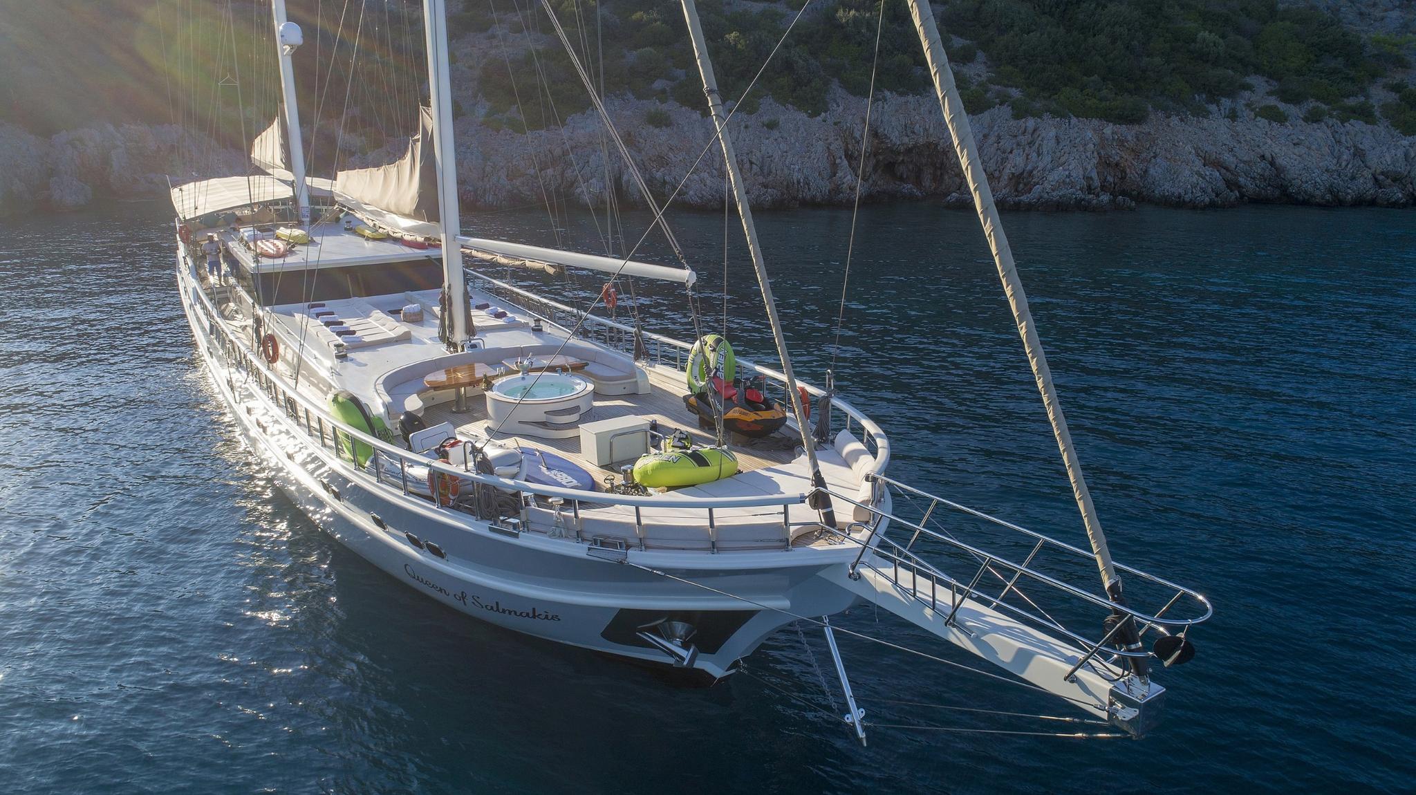 gulet deck with yellow water toys, tender, and recreational equipment at anchor