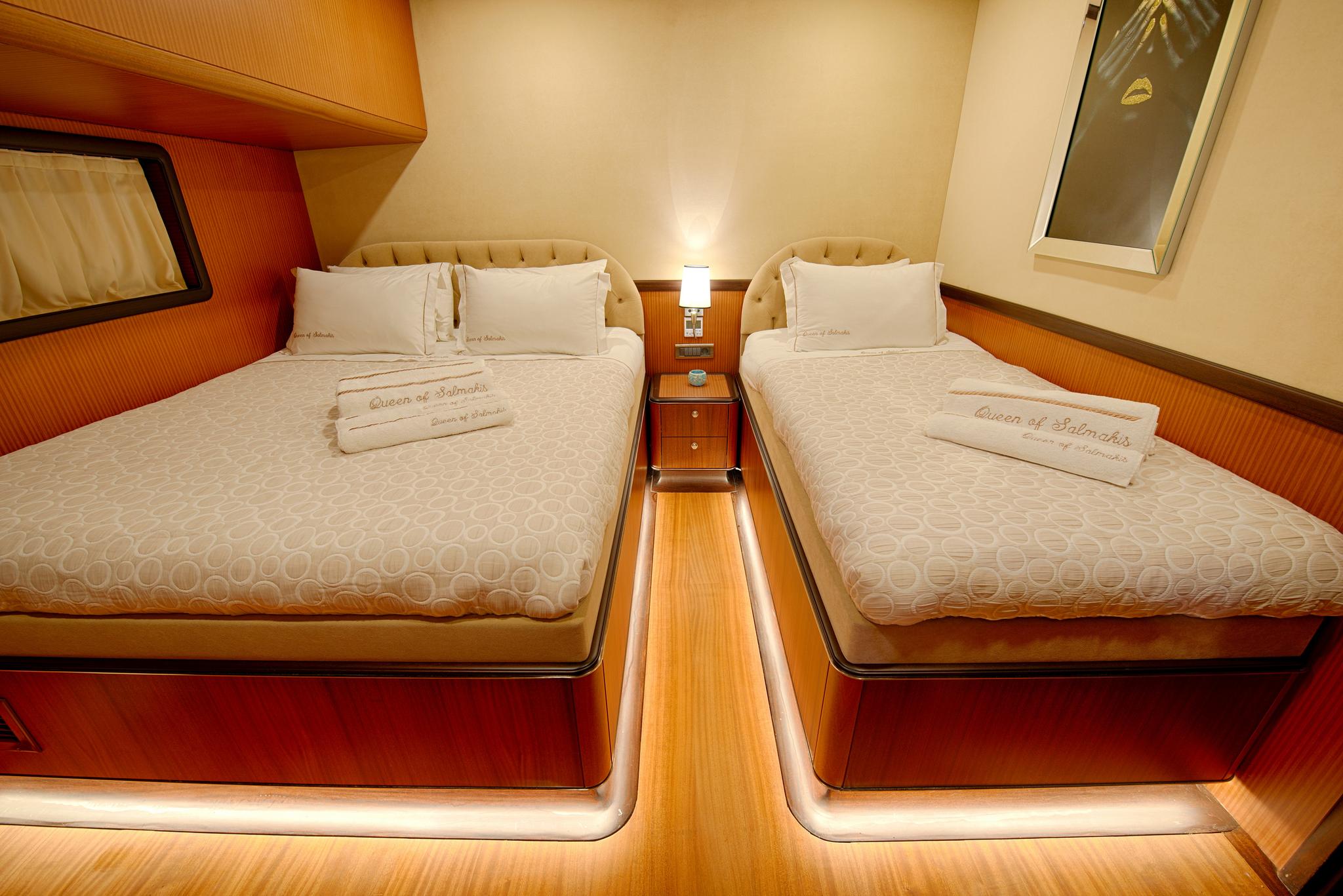 twin guest cabin with two single beds, cream upholstery, and central nightstand