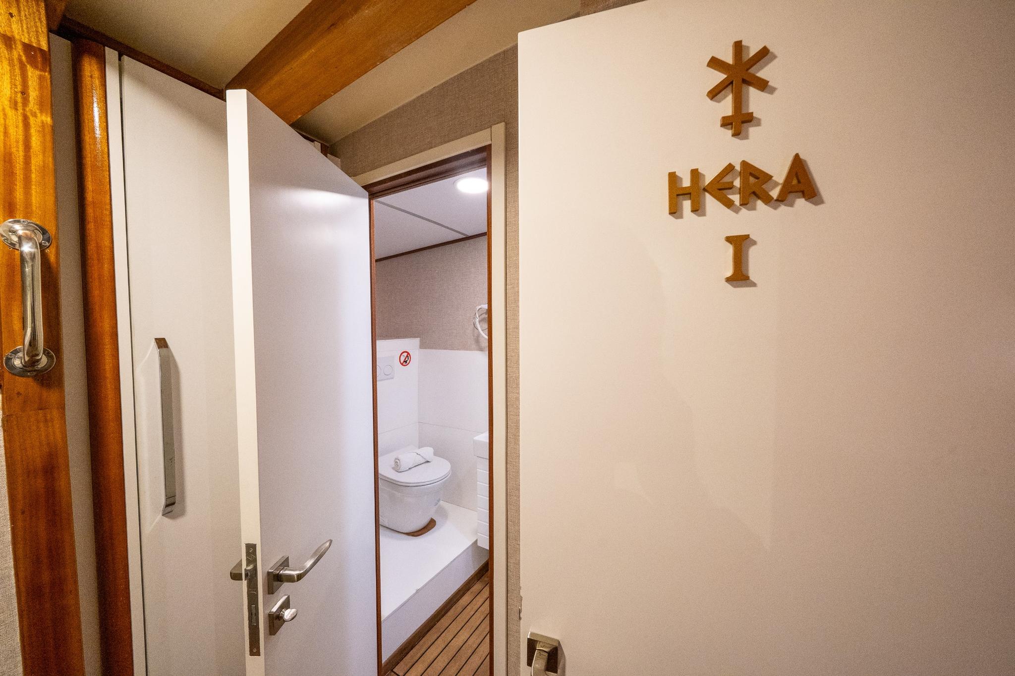 yacht cabin entrance hallway showing Hera I nameplate on wall and open bathroom door