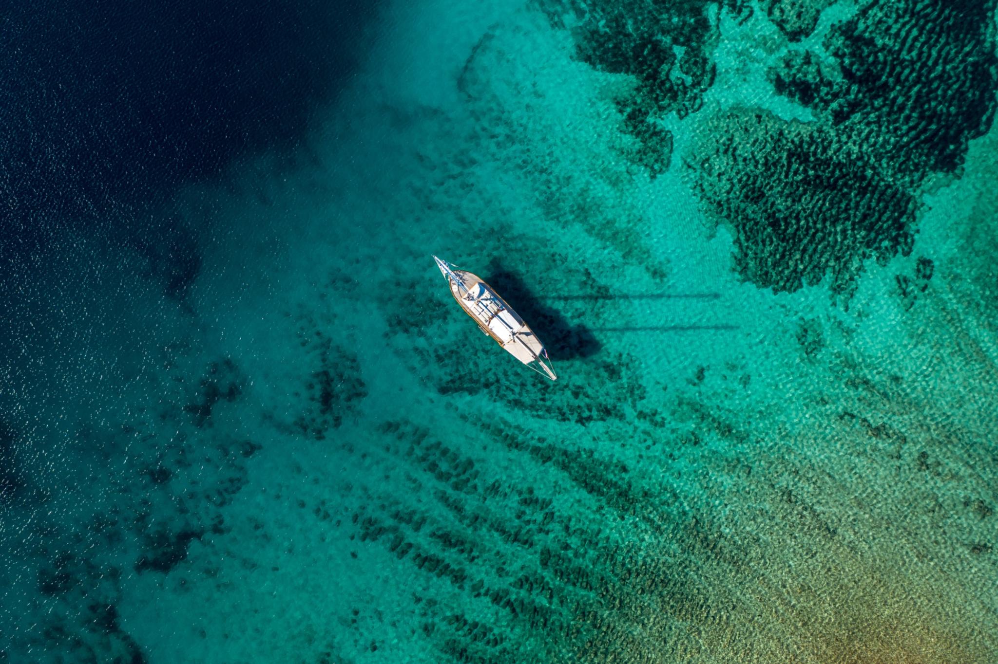 aerial view of traditional gulet yacht anchored in crystal clear turquoise waters