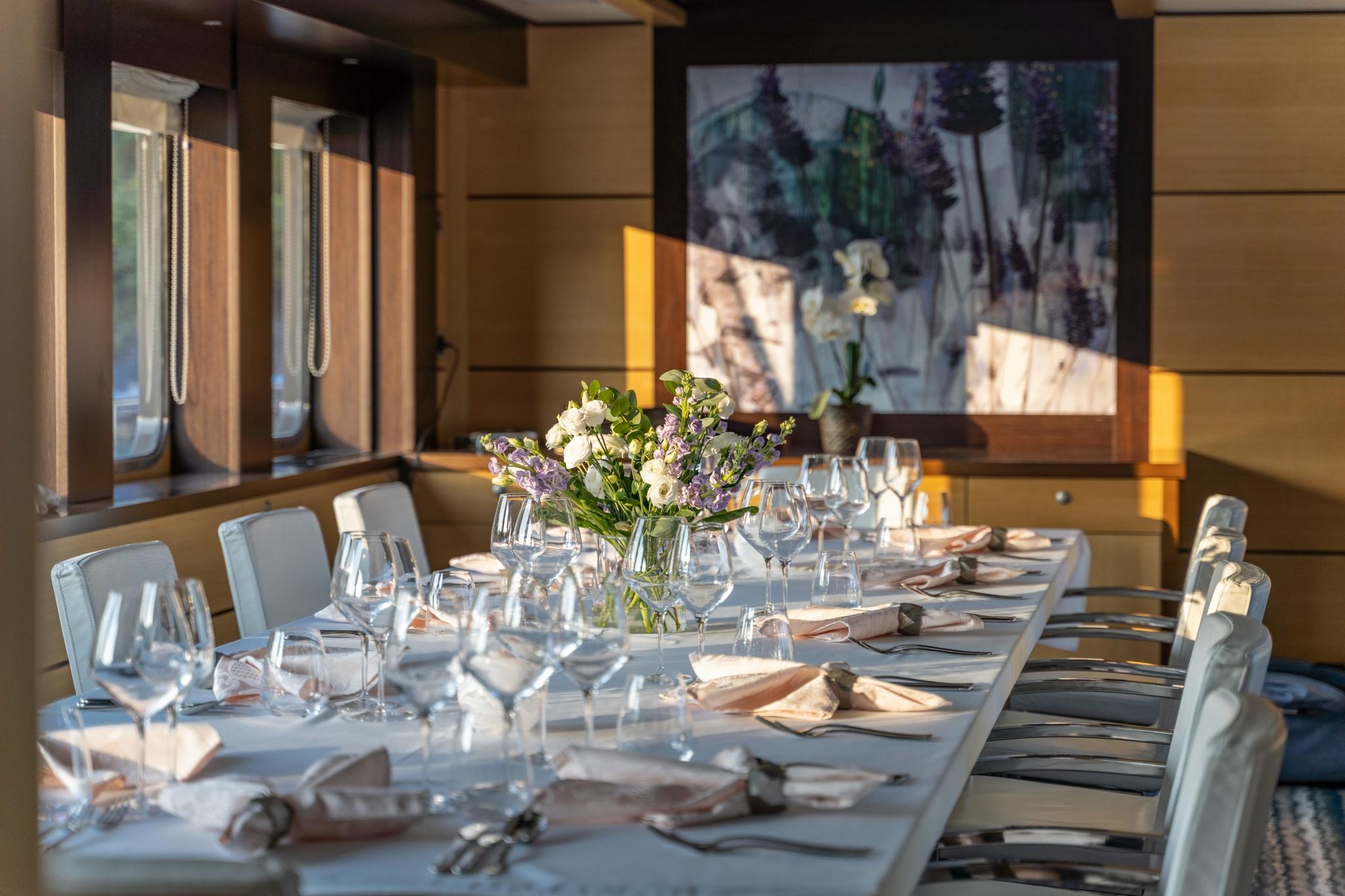 yacht cinema room with projection screen showing movie and formal dining table