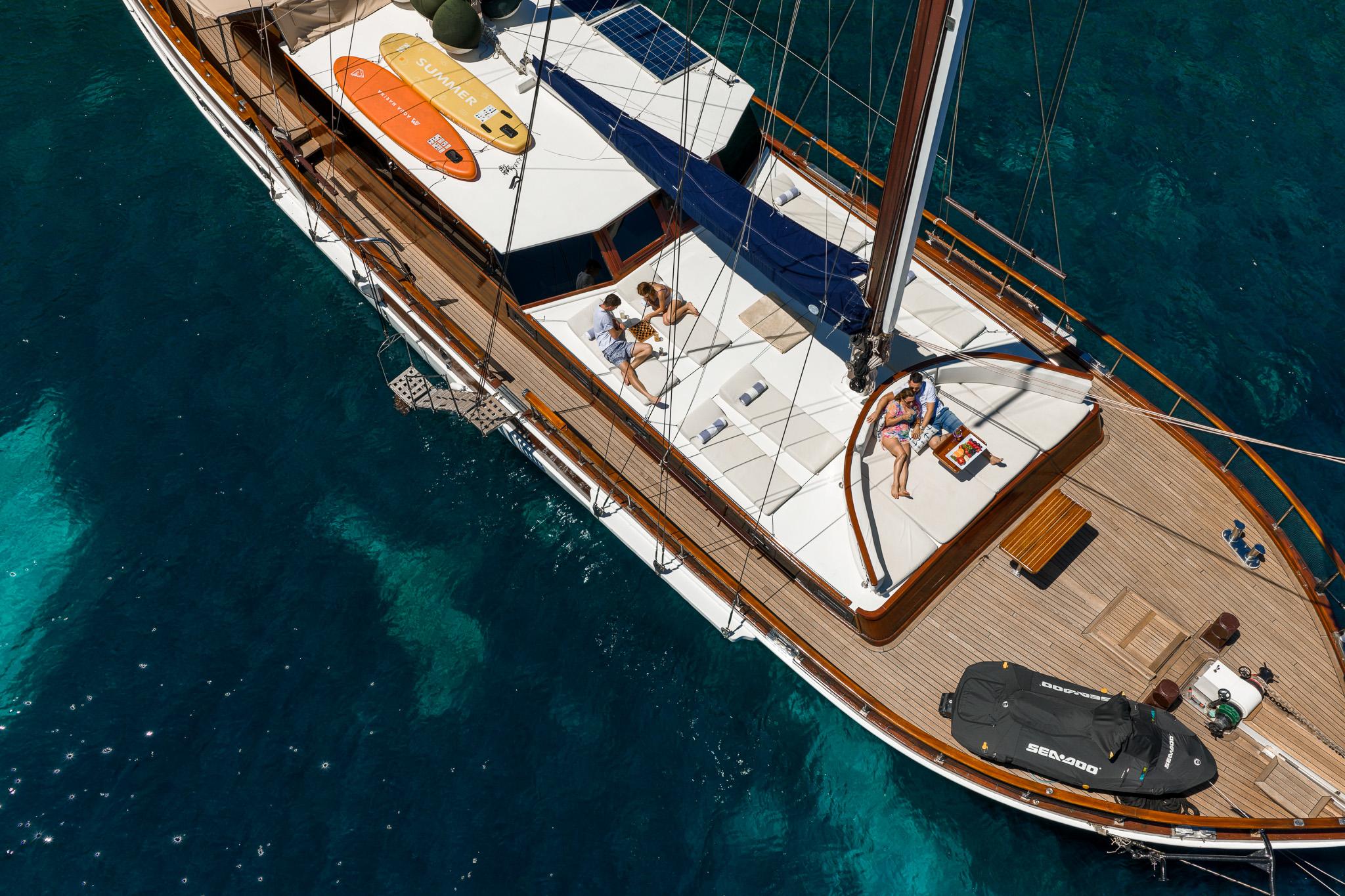 aerial view of luxury gulet showing guests on deck, tender boat and jet ski