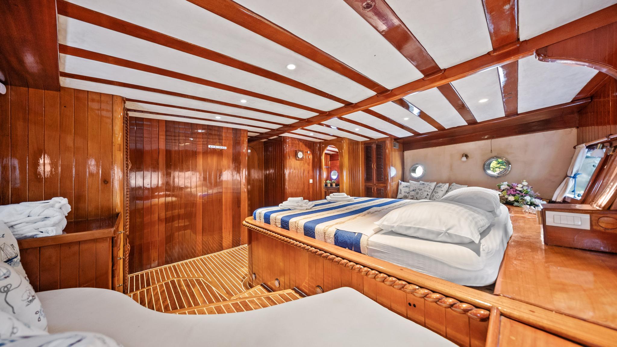 guest cabin featuring double bed with blue striped bedding and polished wood paneling