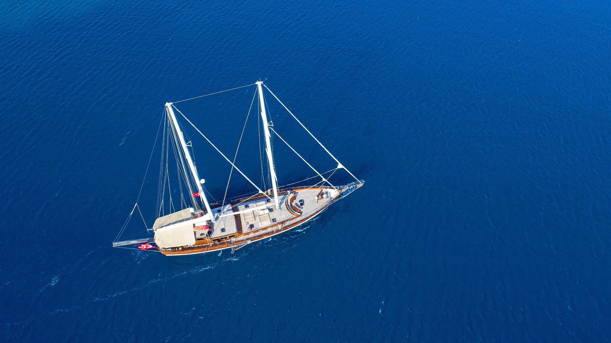 aerial view of traditional wooden gulet yacht with two masts sailing on deep blue Mediterranean waters