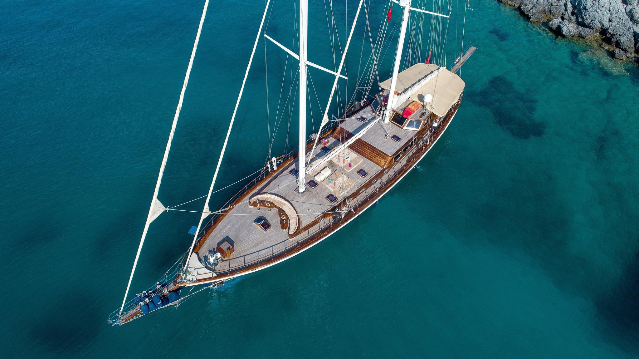 aerial view of traditional wooden gulet yacht anchored in crystal clear turquoise Mediterranean waters