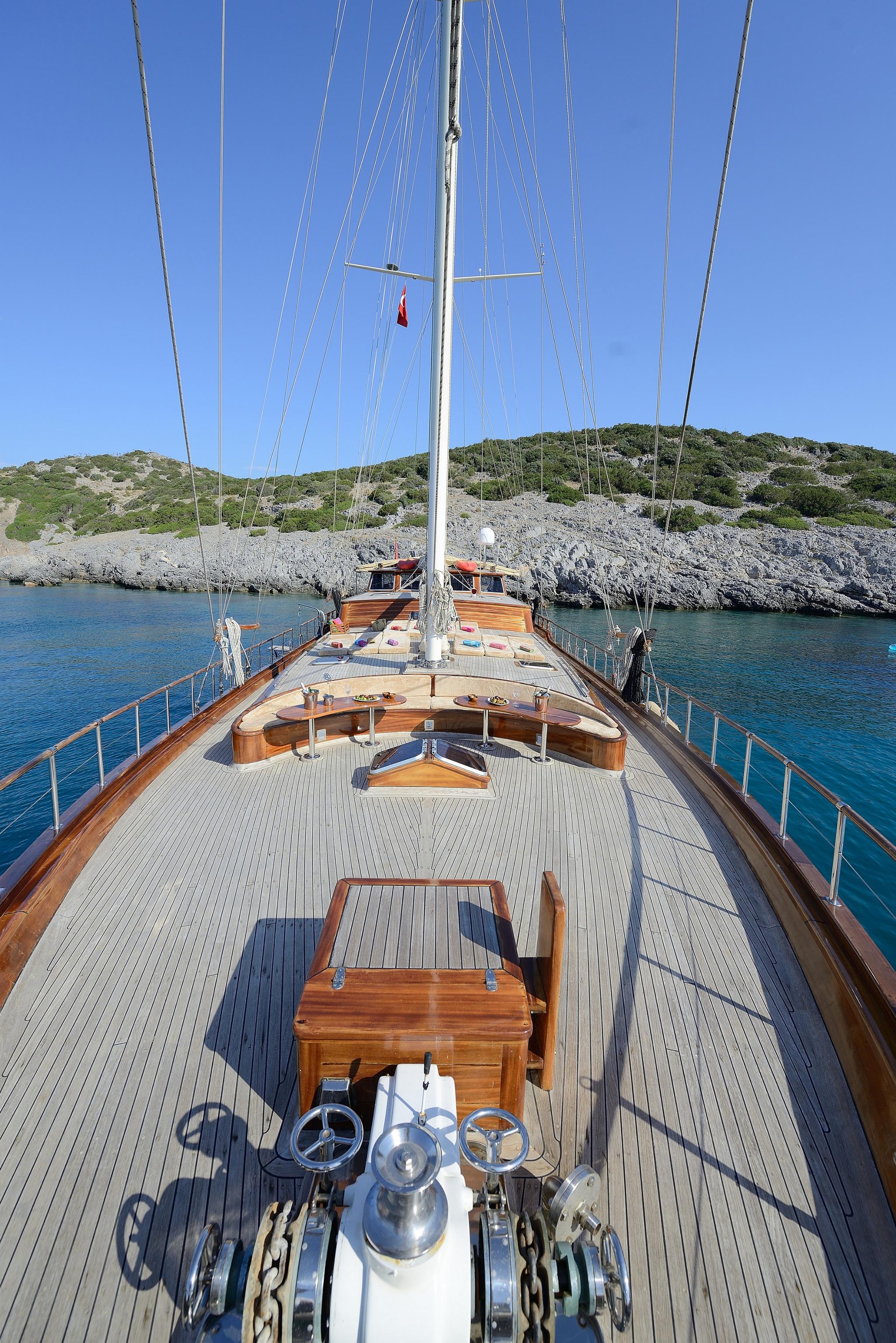 gulet bow deck showing helm station, curved seating, teak decking and anchor windlass