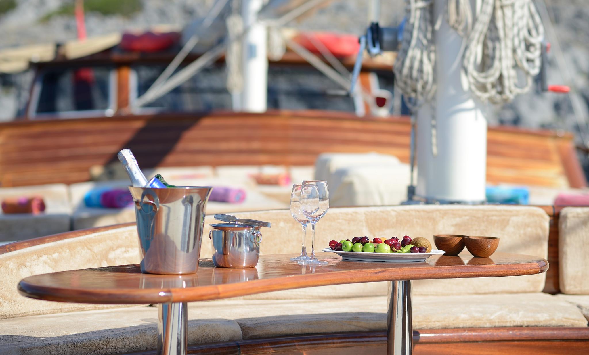 champagne bucket with wine glasses and fresh fruit platter on yacht deck dining table