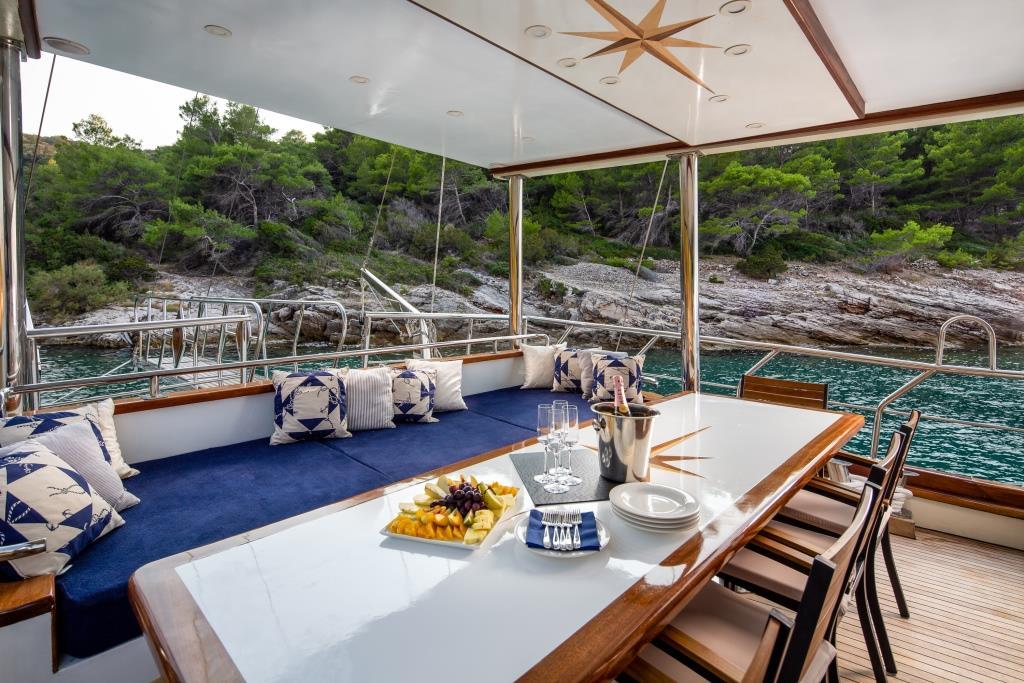luxury yacht aft deck dining table set with champagne and fruit platter